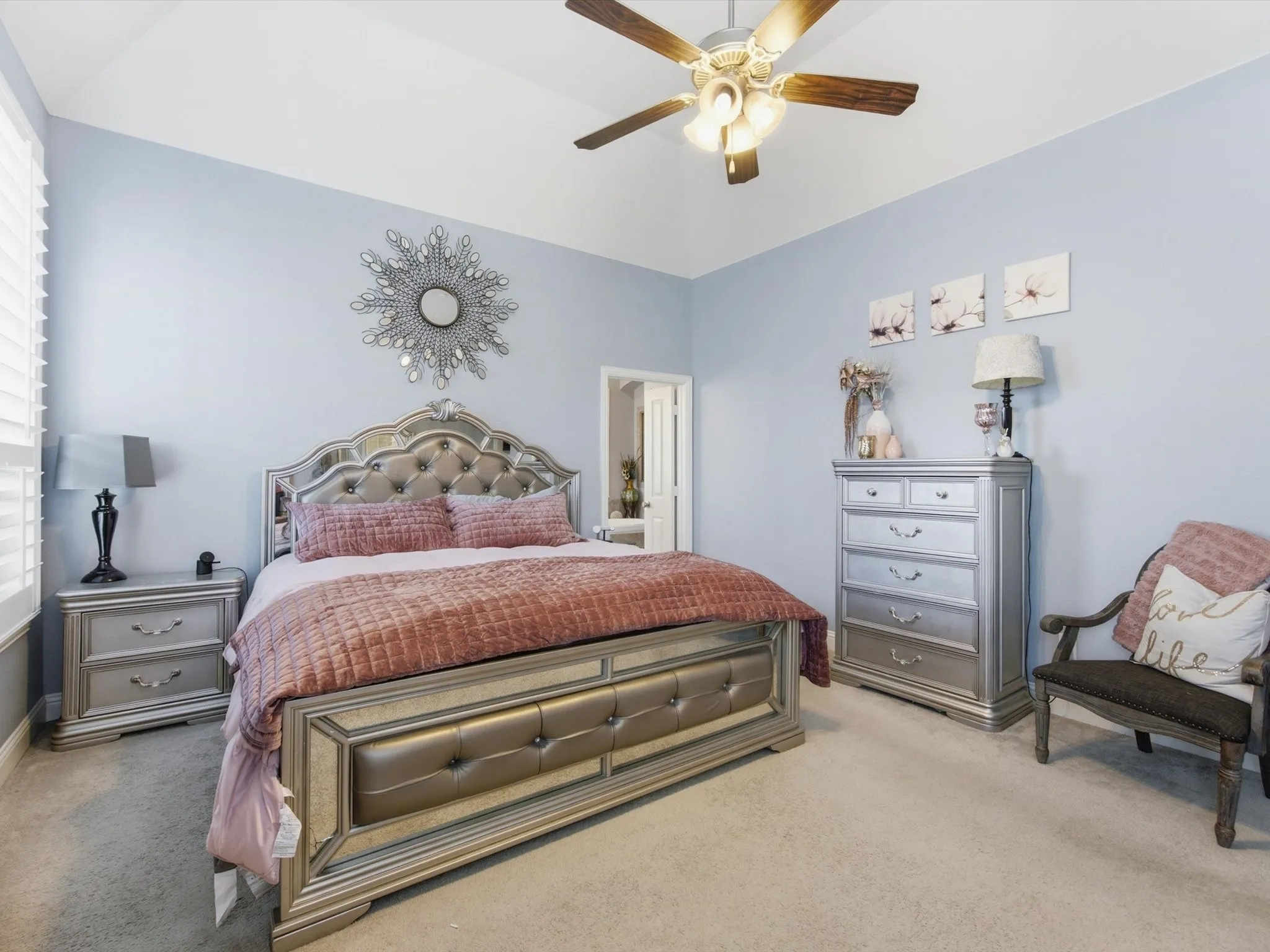 Vaulted ceiling in Primary Bedroom featuring a ceiling fan with integrated lighting, window with horizontal blinds, and neutral carpet flooring