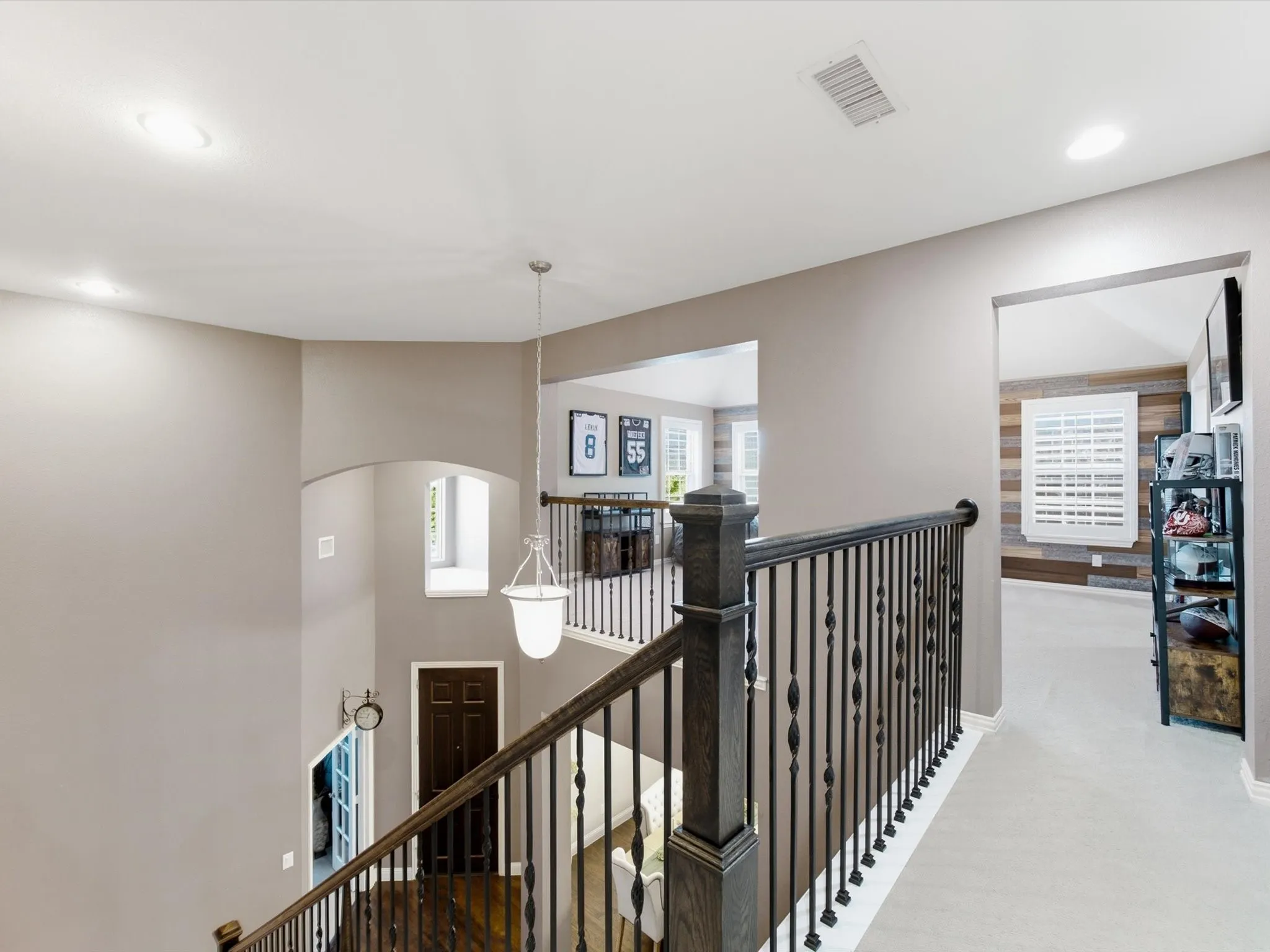 Staircase featuring dark wood-finish treads and risers, wrought iron balusters, and a matching dark wood newel post