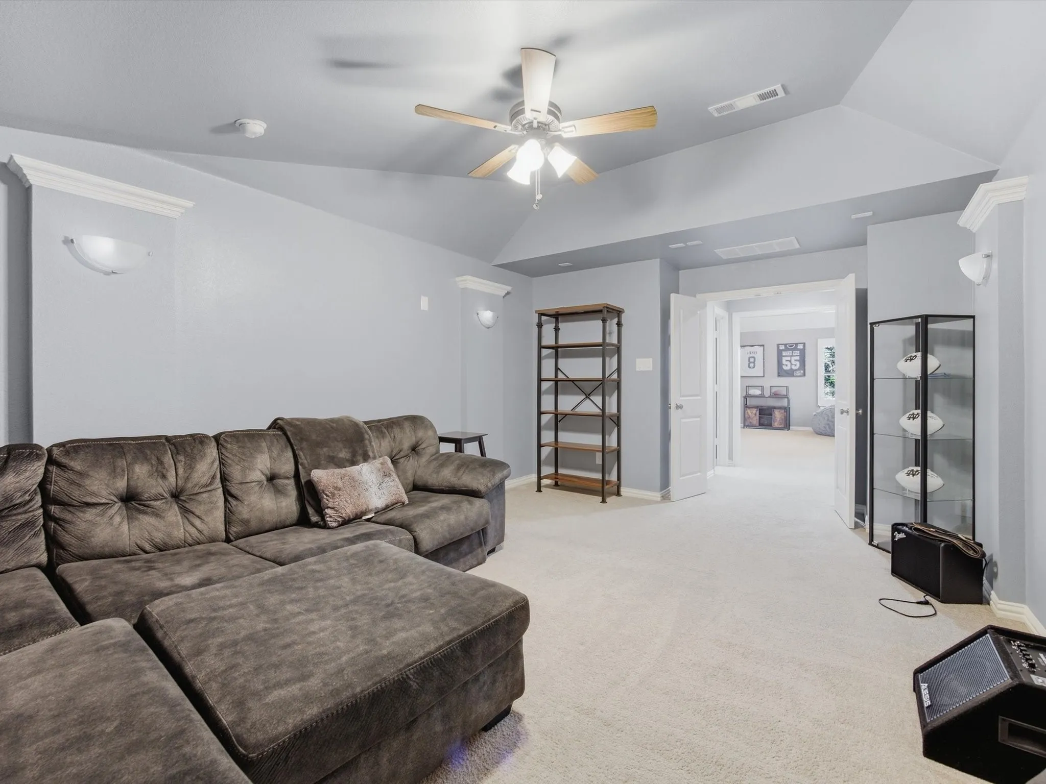 Carpeted Media Room featuring a vaulted ceiling with a fan, wall sconces, double doors, and crown molding accents