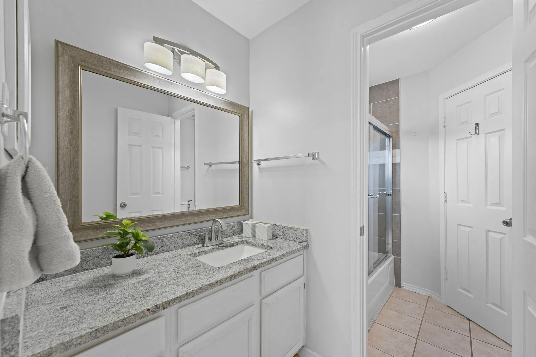 Bathroom vanity featuring a granite countertop, undermount sink, and brushed nickel faucet