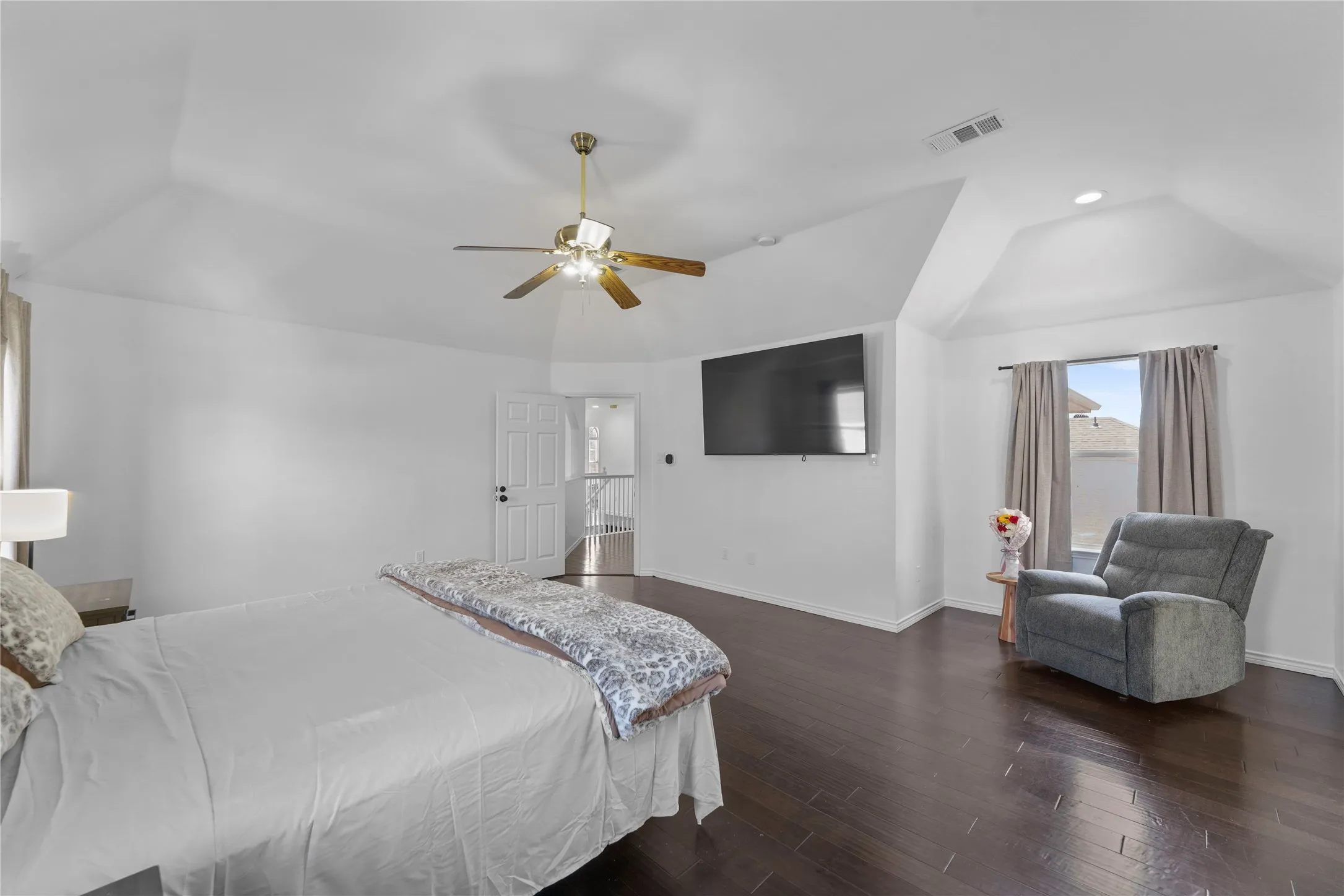 Vaulted ceiling room featuring dark wood-finish flooring, a ceiling fan with integrated lighting, and recessed lighting