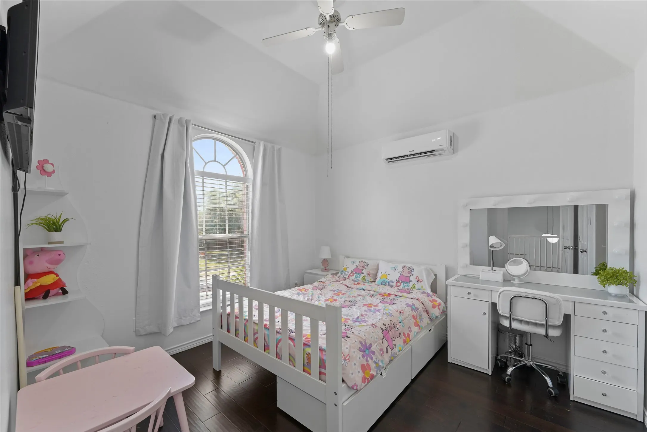 Bedroom featuring vaulted ceilings, wood-finish flooring, an arched window, a ceiling fan, and a wall-mounted mini-split AC unit