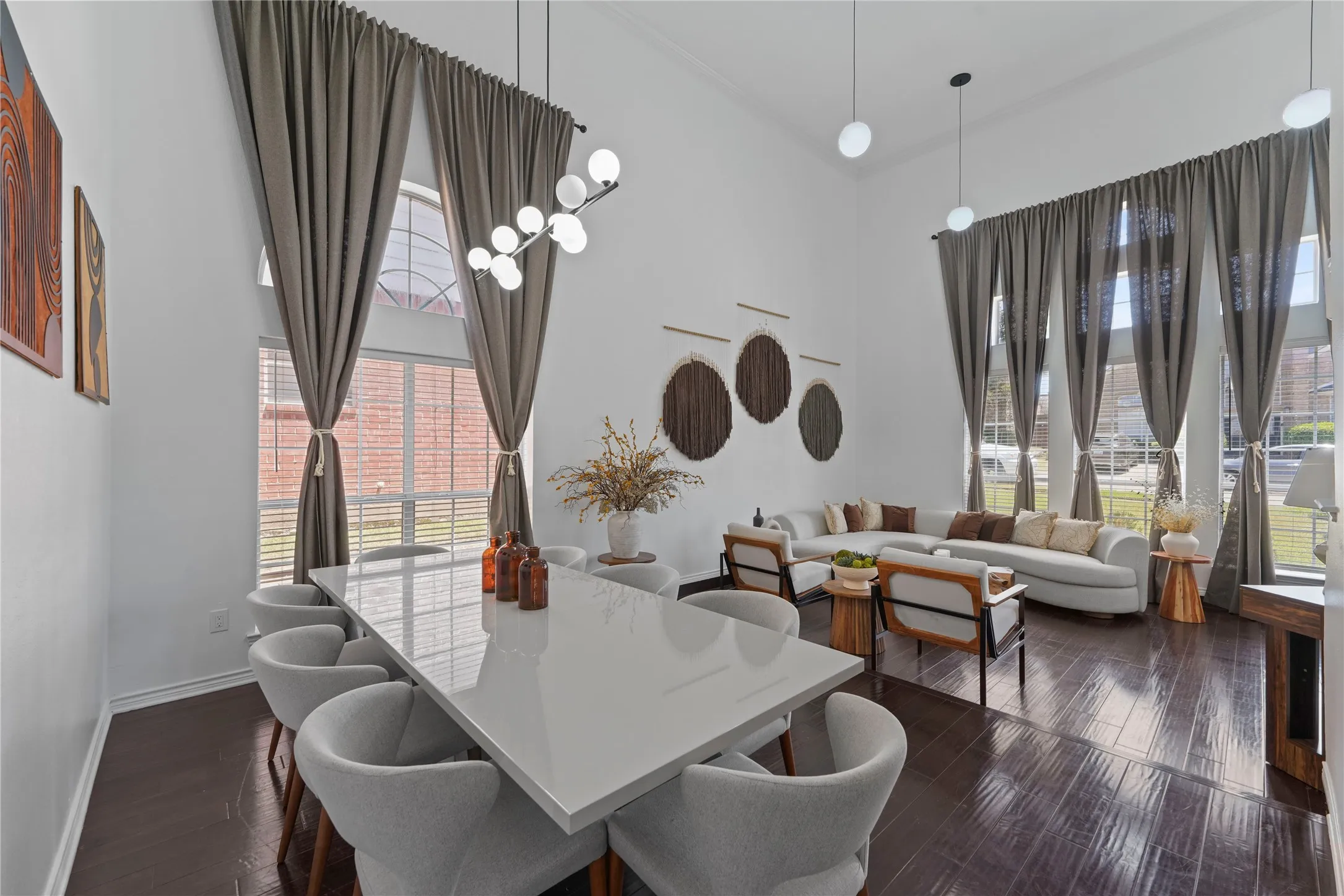 Open-concept living space featuring high ceilings, dark wood-finish flooring, and expansive windows