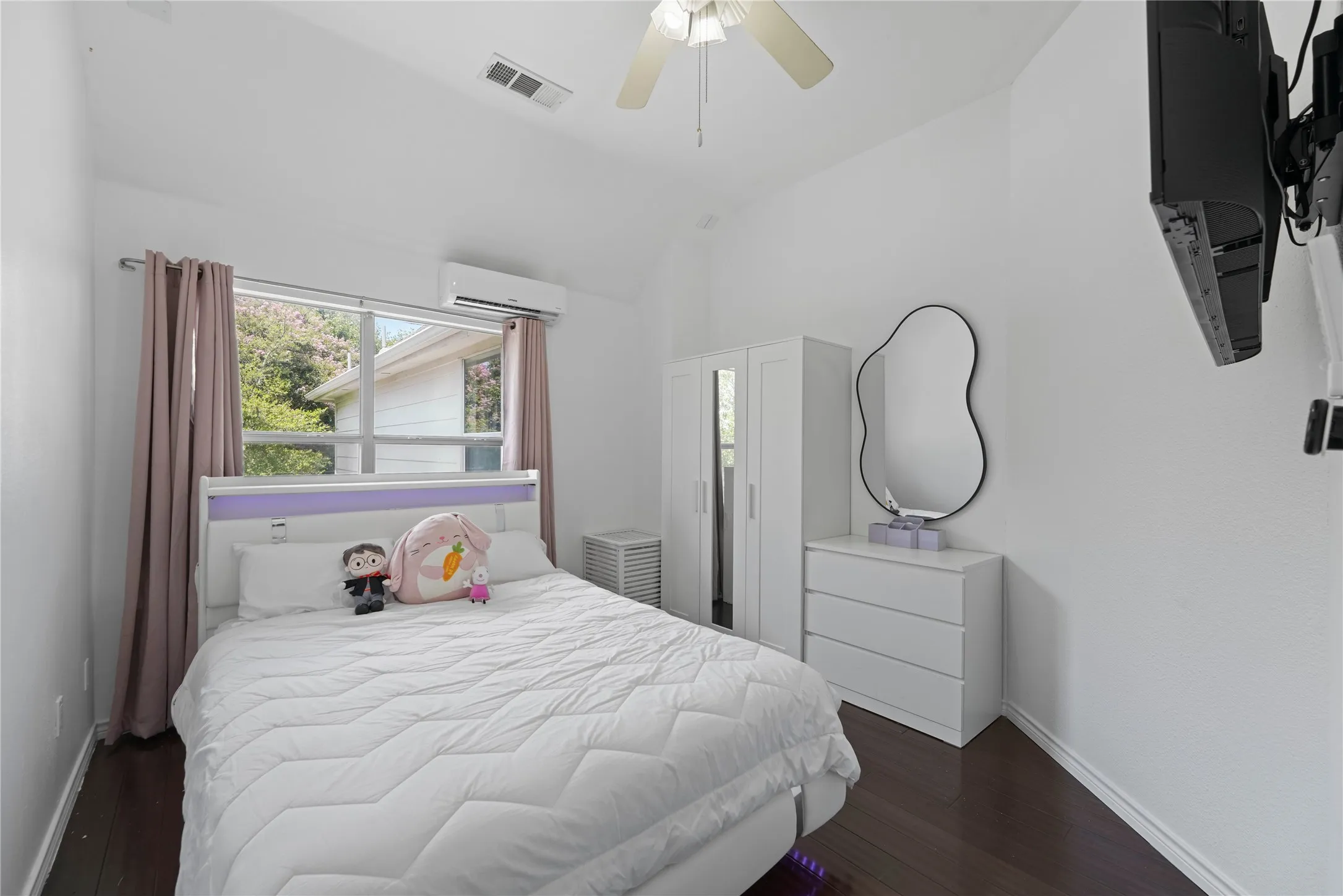 Room featuring dark wood-finish flooring, white painted walls, and a vaulted ceiling