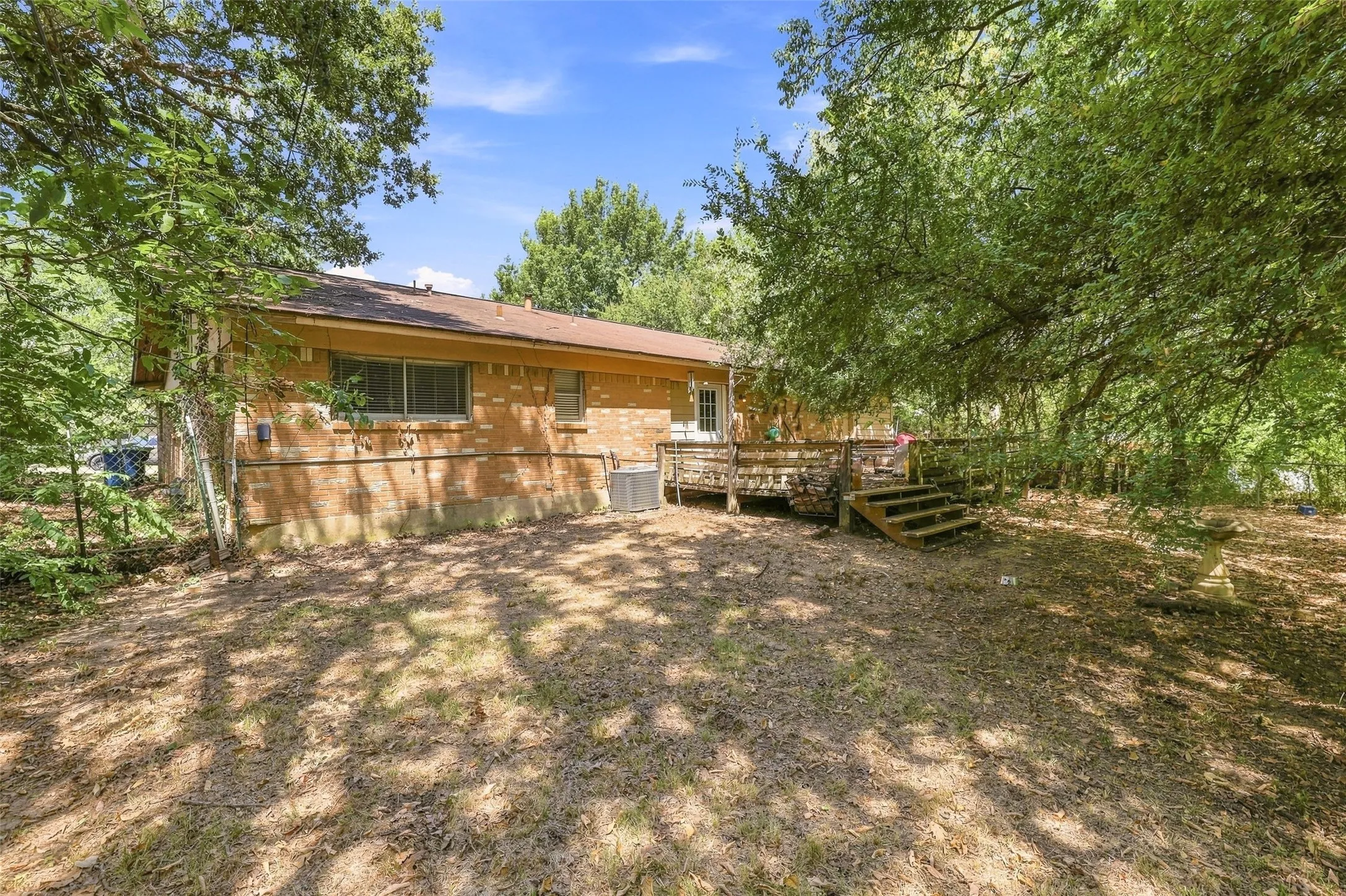 Brick exterior, raised wood deck, and mature trees