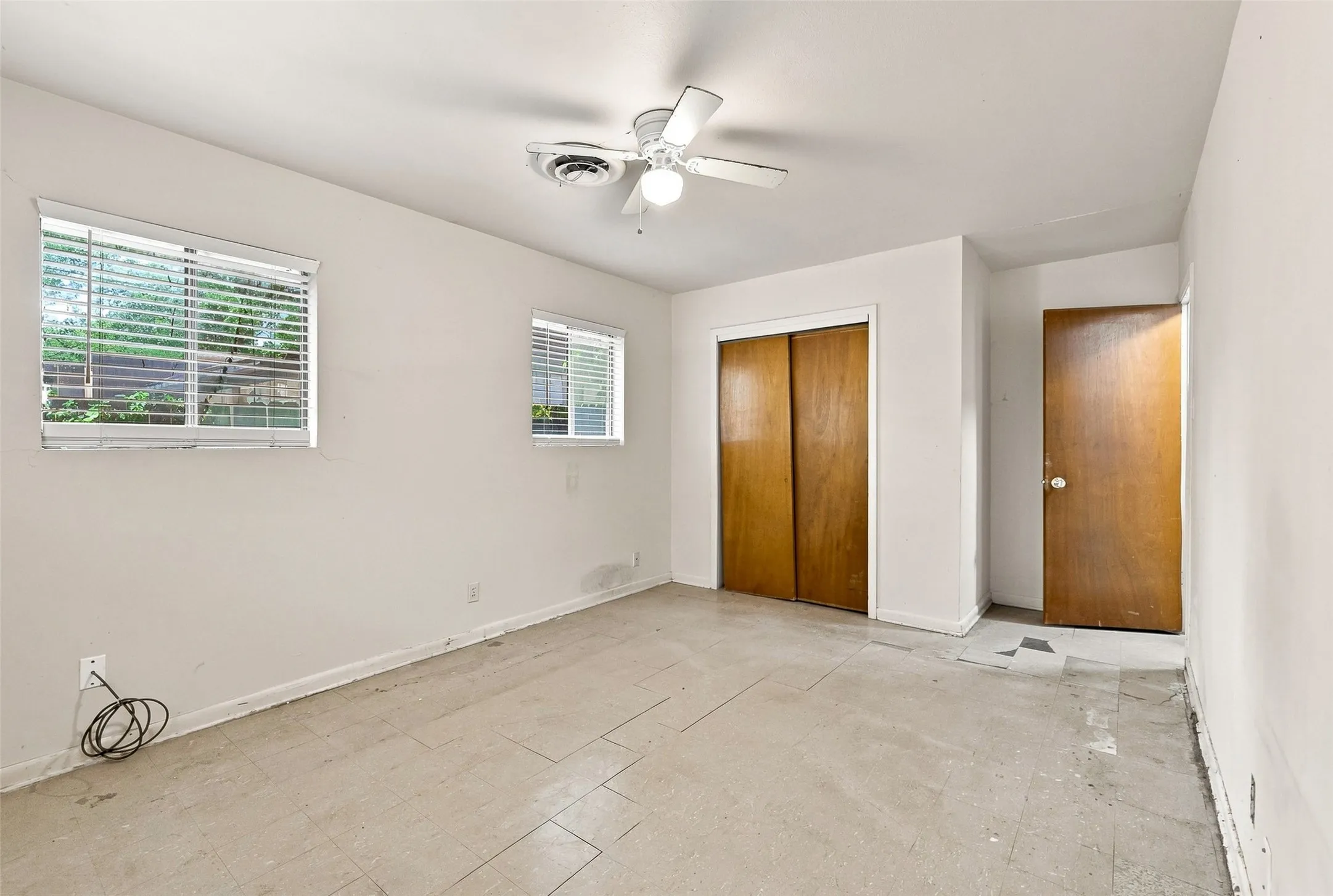 Recessed lighting, ceiling fan, two windows with blinds, wood-finish bi-fold closet doors, and wood-finish door