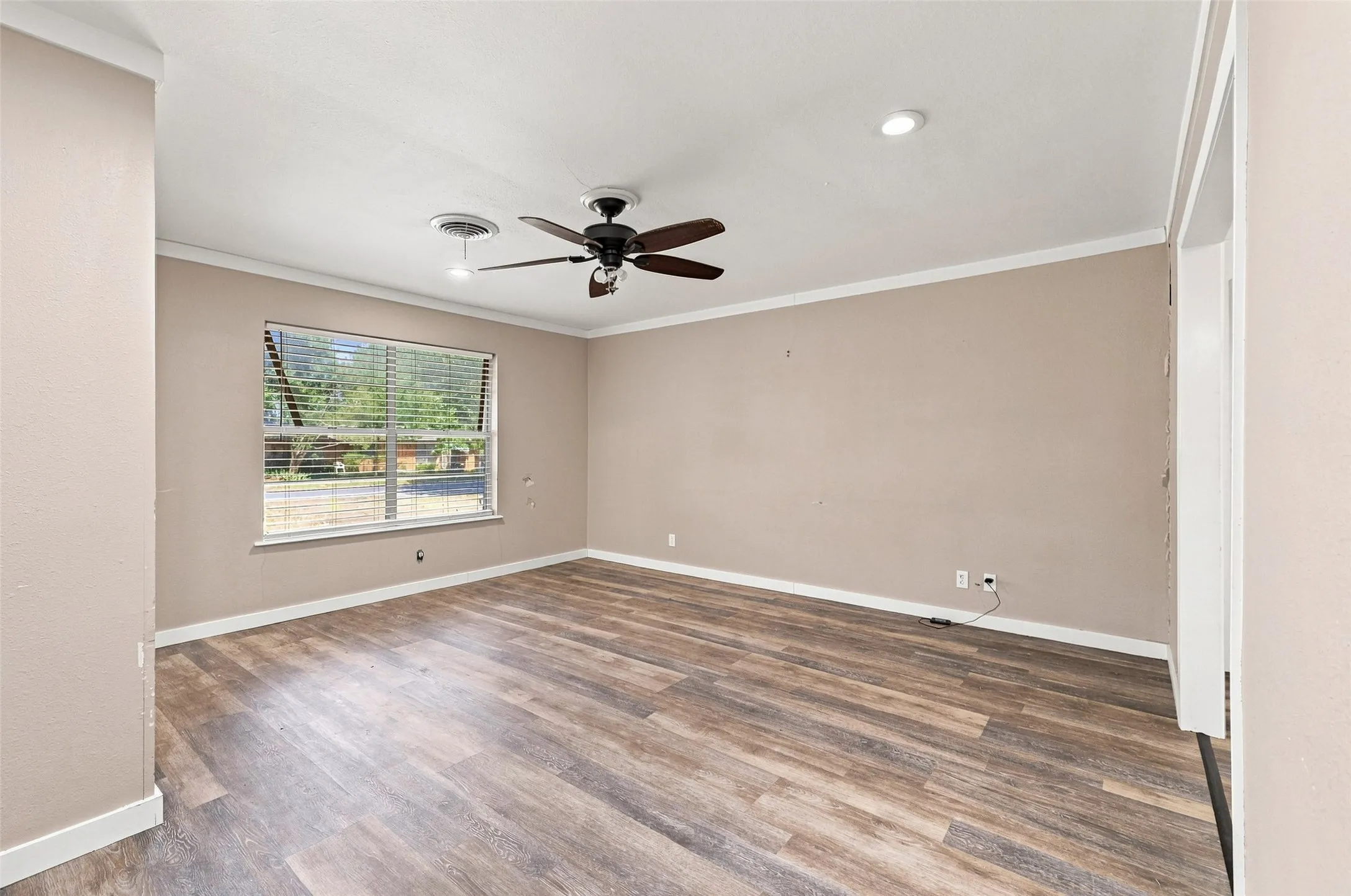 Wood-finish flooring, recessed lighting, ceiling fan, crown molding, and window with blinds