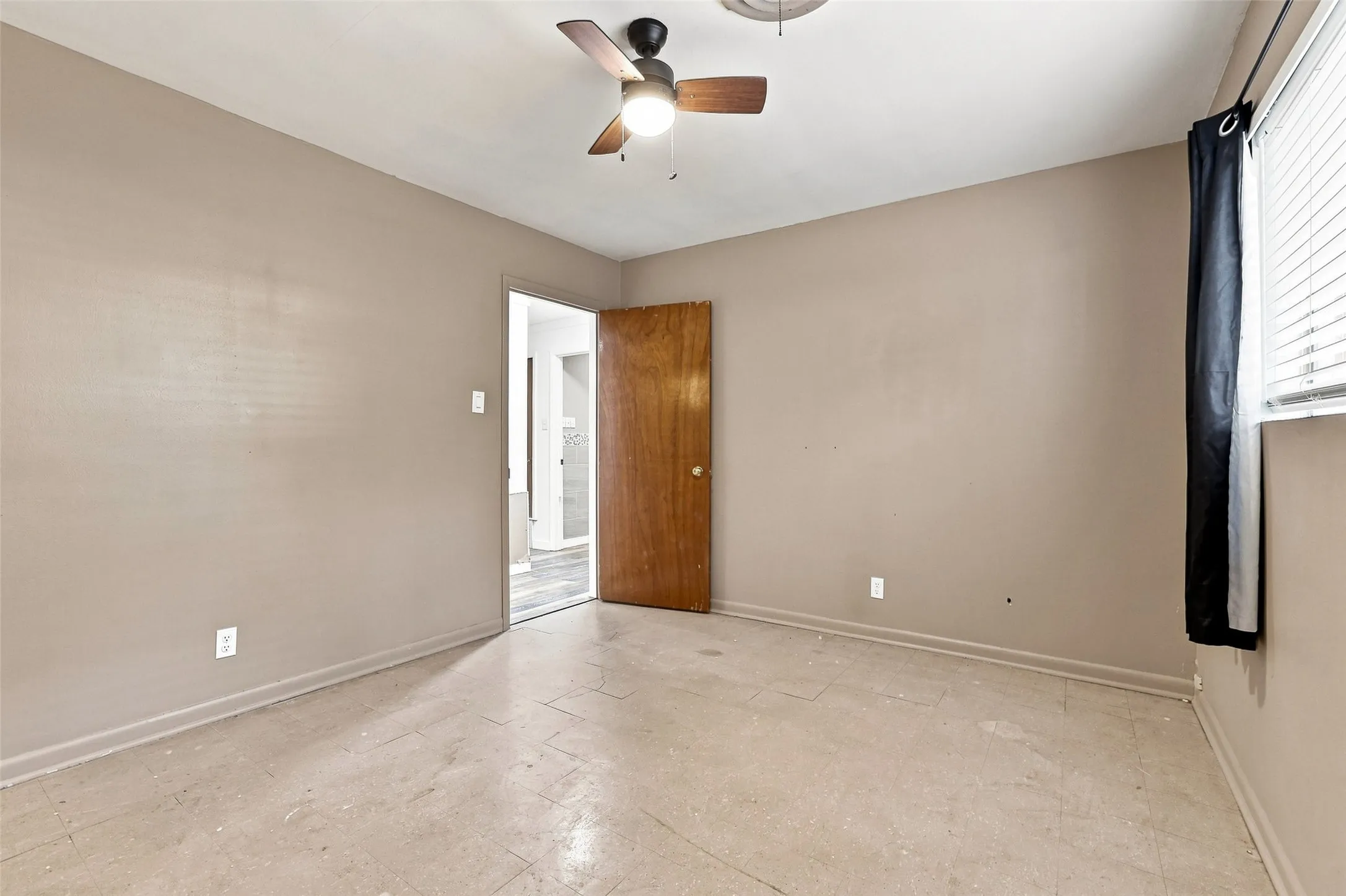Ceiling fan with light fixture, window with blinds, and wood-finish door