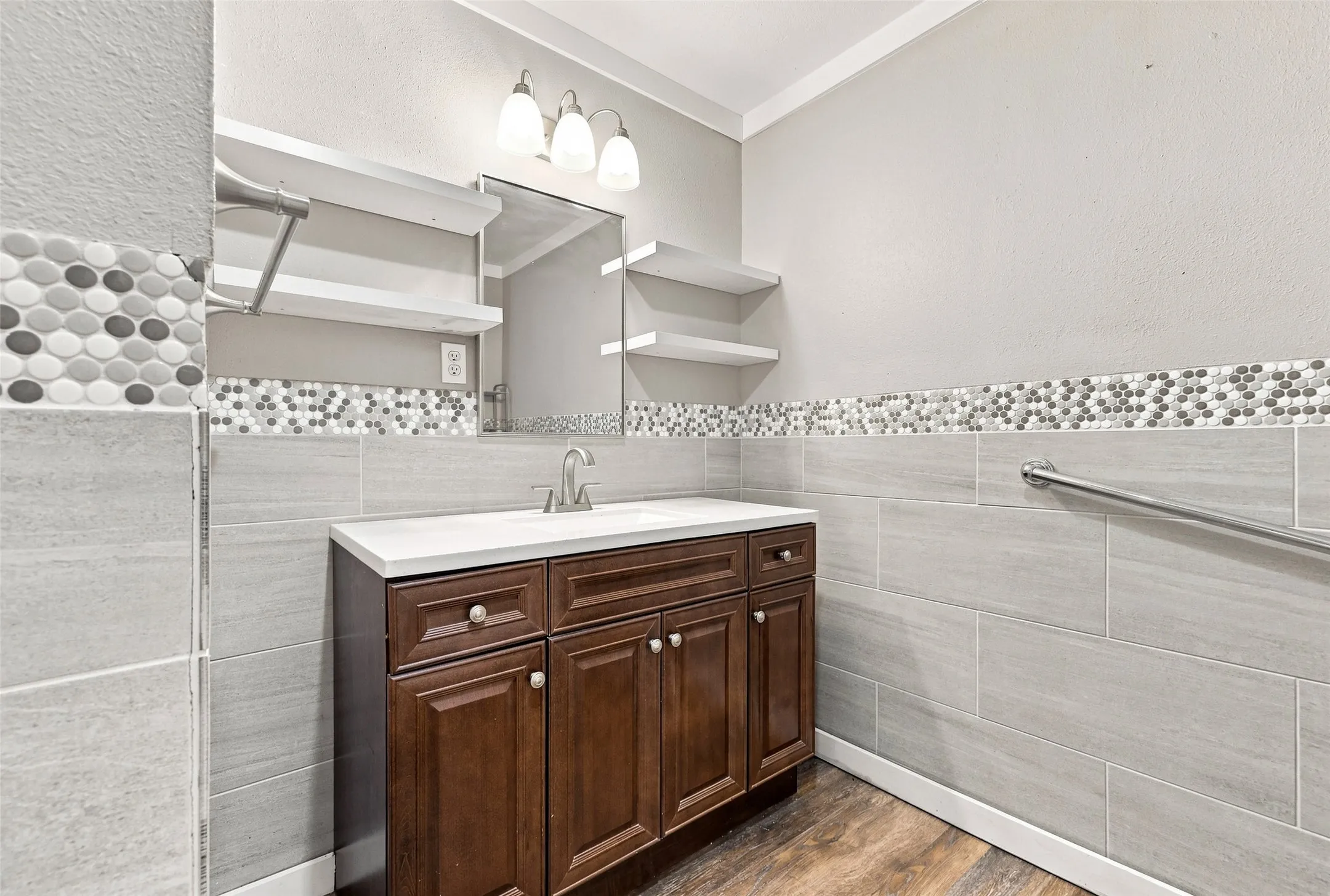 Brown wood-finish vanity with a white countertop and undermount sink