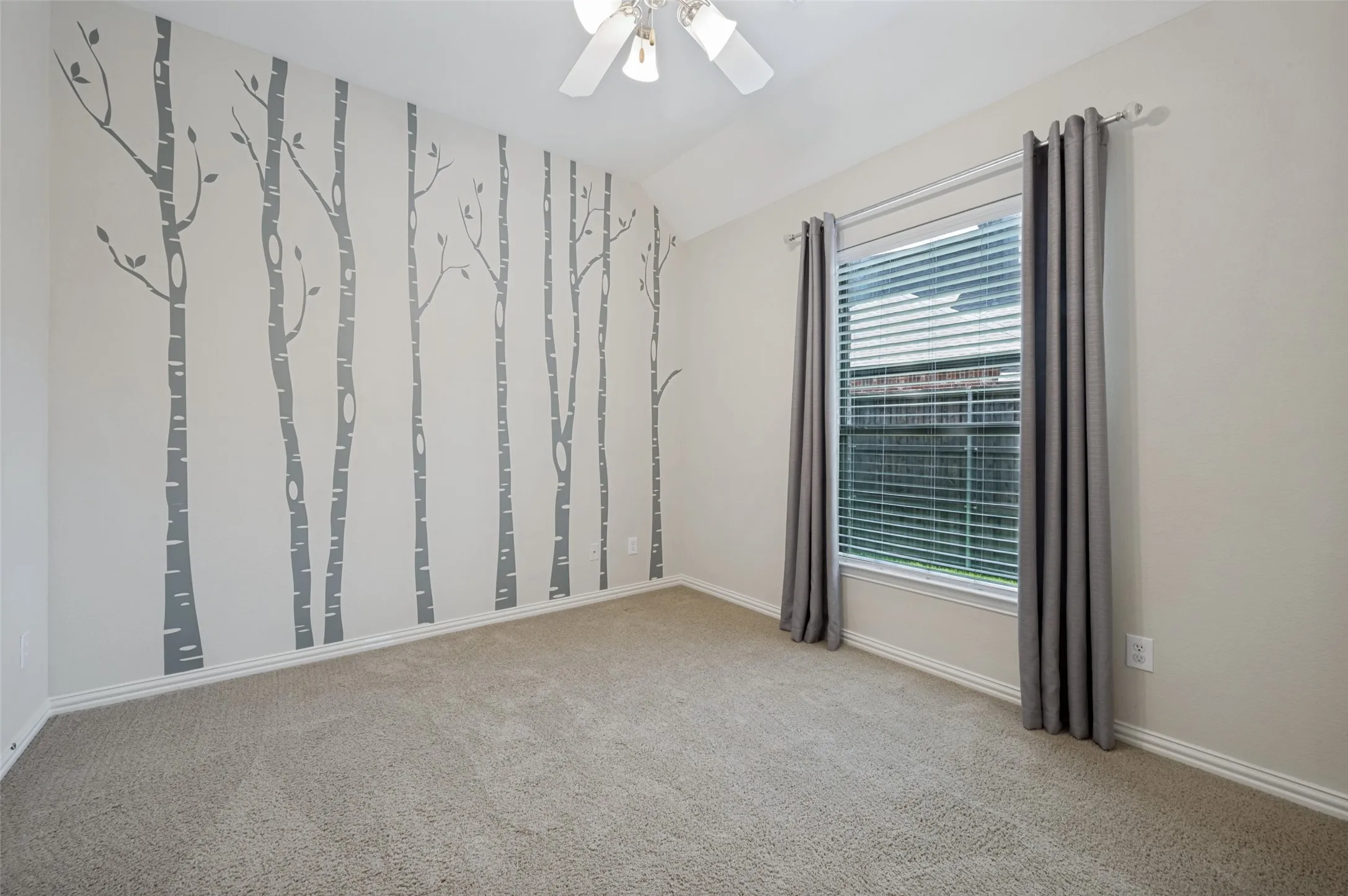 Generously sized secondary bedroom featuring soaring ceilings, a large window that fills the room with natural light, and a spacious closet. This versatile space offers comfort and flexibility, making it ideal for family, guests, or a home office.