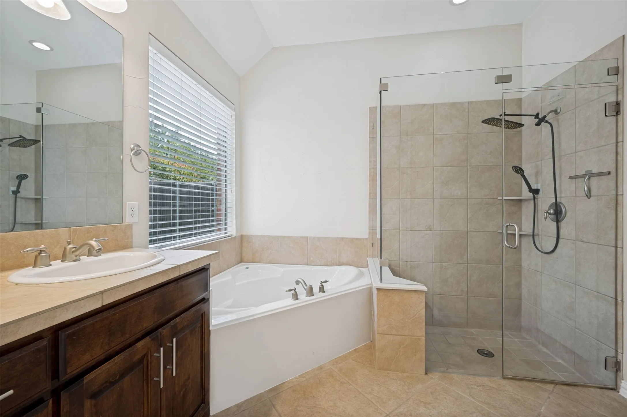 Unwind in the relaxing garden tub or enjoy the large frameless glass walk-in shower, all enhanced by soaring ceilings, abundant natural light, and timeless finishes that create a bright, spa-inspired retreat.