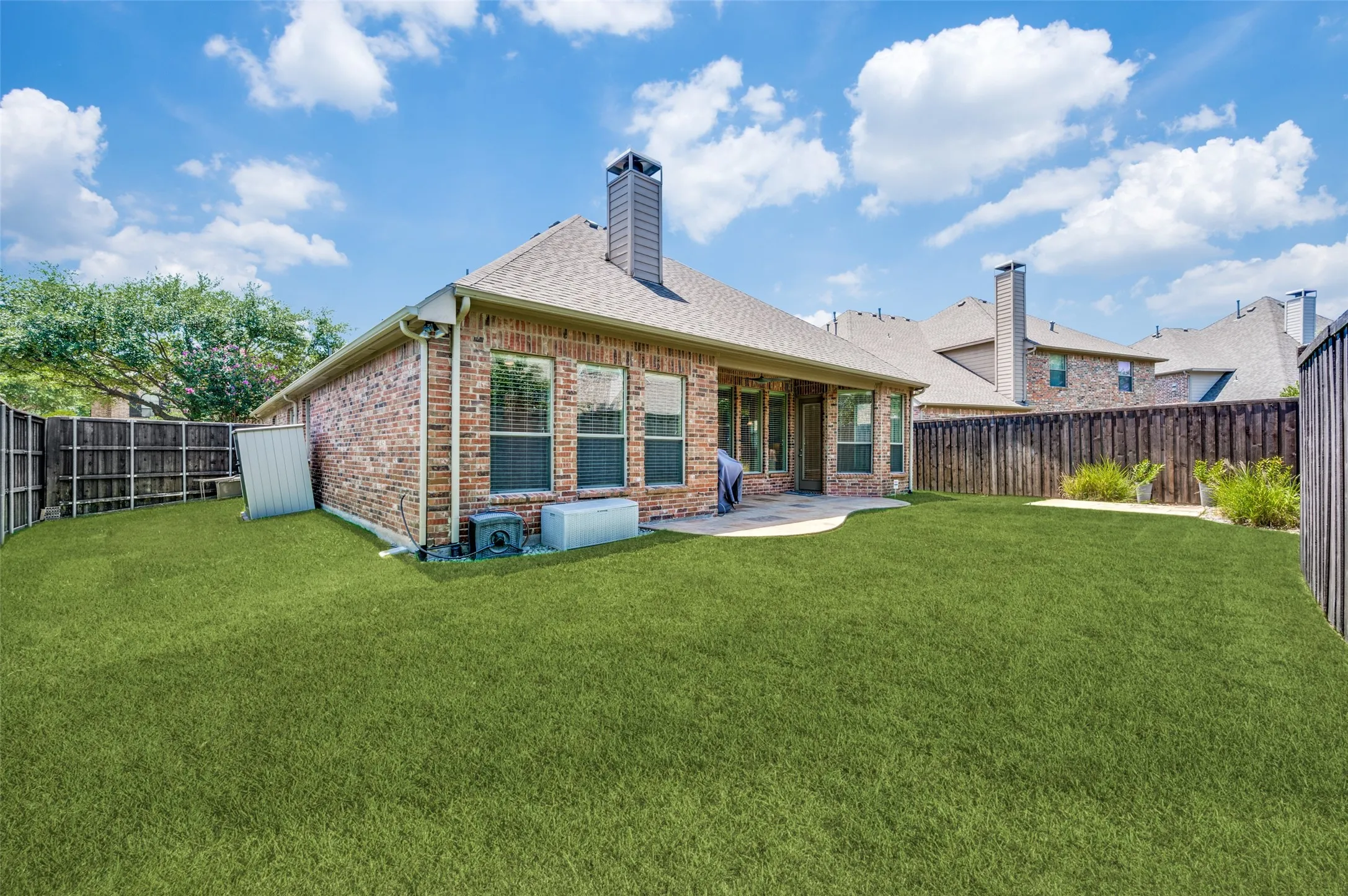 Oversized backyard with lush natural grass, an 8-foot privacy fence, and plenty of room for kids, pets, play, or outdoor entertaining.