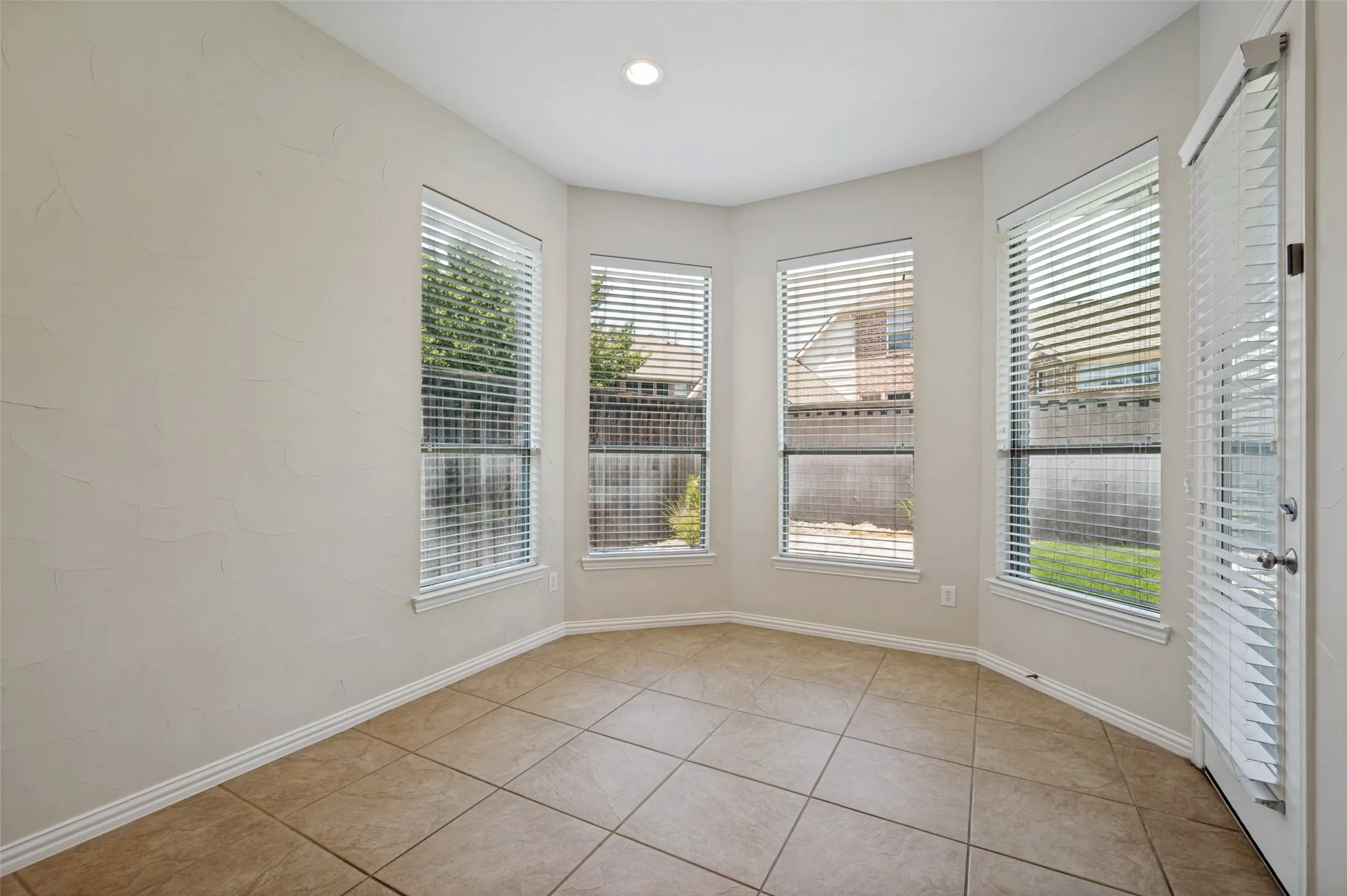 The spacious breakfast area is surrounded by windows, filling the space with natural light and creating the perfect setting for everyday dining.