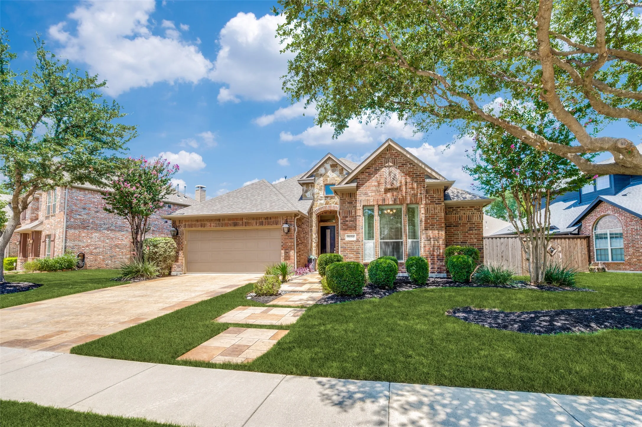 This beautifully designed home offers exceptional curb appeal with a striking brick and stone elevation, professionally landscaped grounds, and an inviting stone walkway leading to the covered front porch.