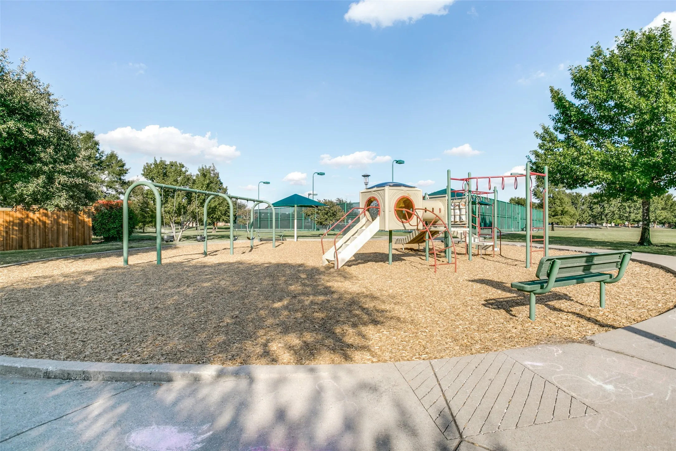 The neighborhood park offers a fun place for all ages to enjoy, featuring a playground, swings, shaded seating, and open green space for outdoor recreation and family gatherings.