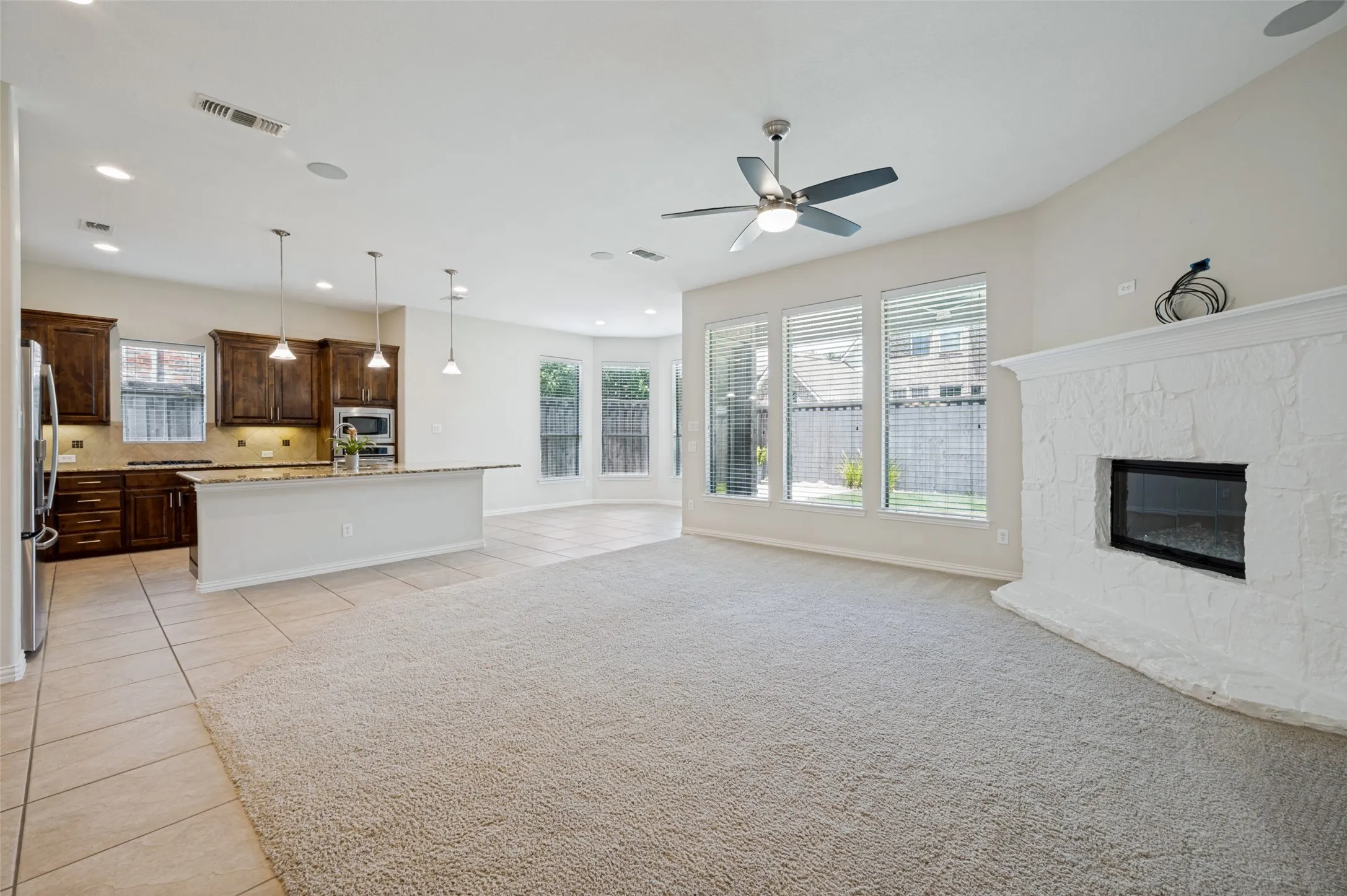 A wall of windows fills the space with natural light, while the upgraded stone fireplace creates a beautiful focal point, making this home ideal for both everyday living and entertaining.