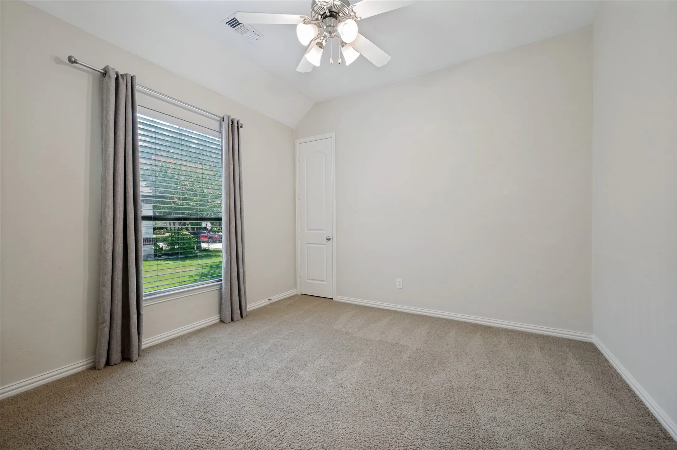 Generously sized secondary bedroom featuring soaring ceilings, a large window that fills the room with natural light, and a spacious closet. This versatile space offers comfort and flexibility, making it ideal for family, guests, or a home office.