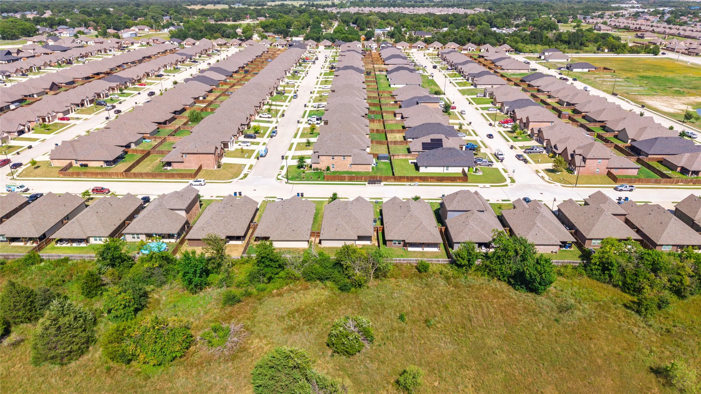 Aerial perspective showcasing a residential community with uniform brown roofs