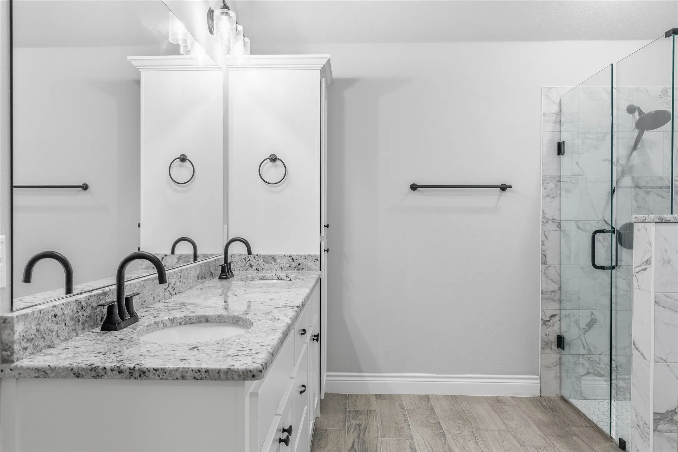 Double vanity featuring stone countertops with undermount sinks and matte black fixtures