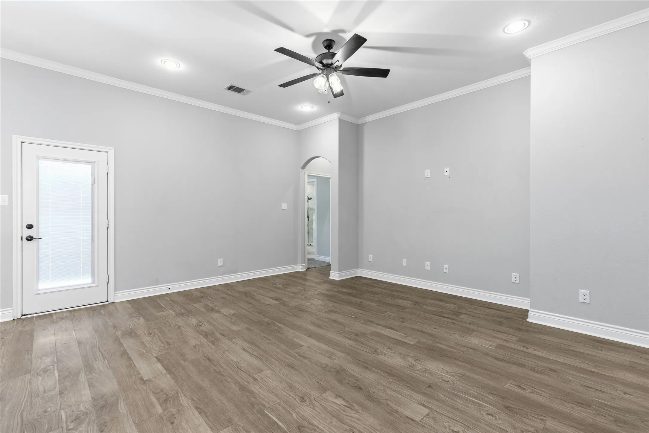 Spacious room featuring wood-finish flooring, recessed lighting, and a ceiling fan
