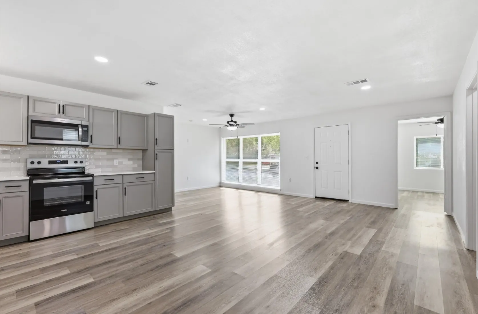 Open concept living area featuring wood-finish flooring, recessed lighting, and a ceiling fan