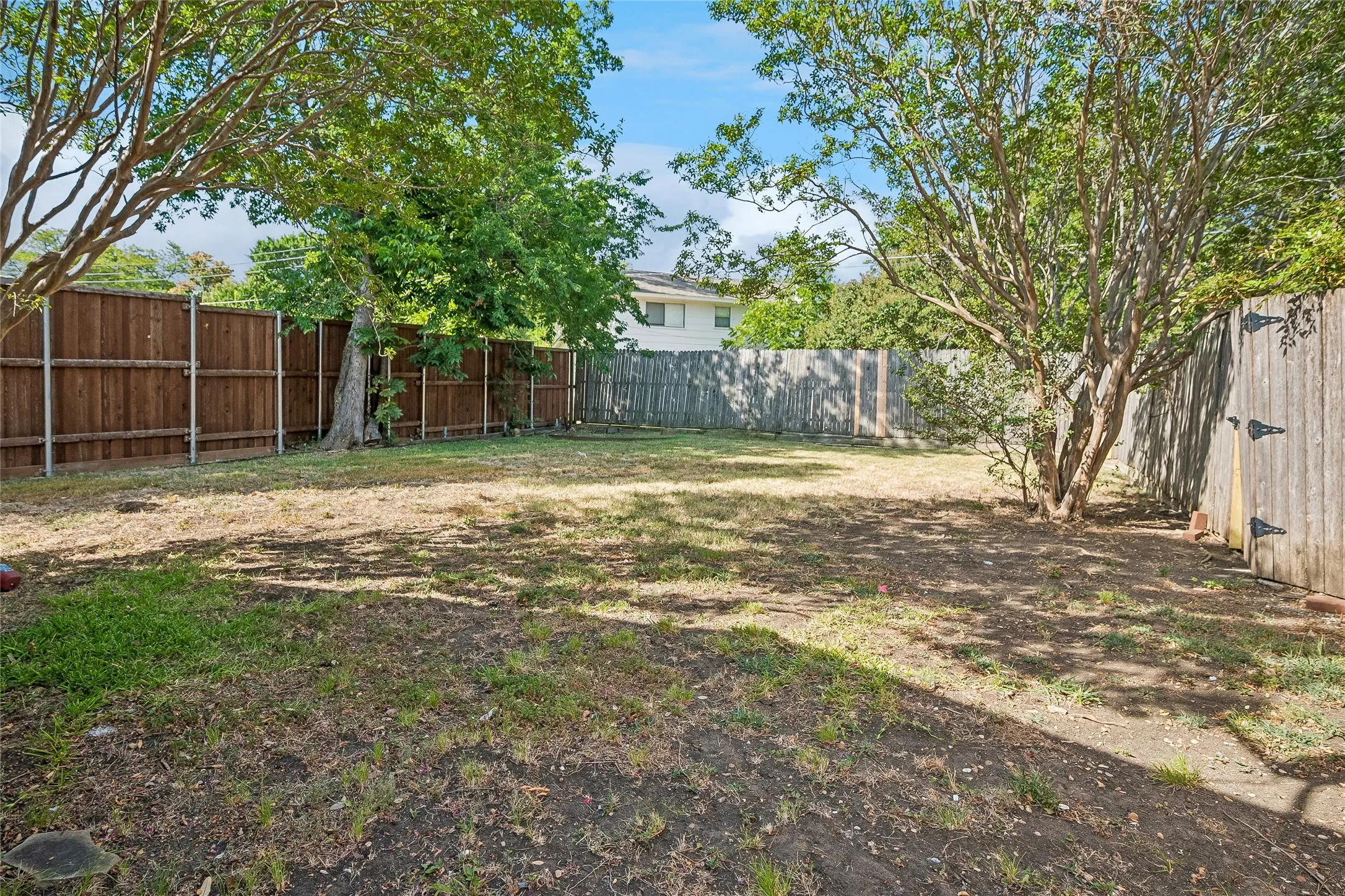 Large backyard with wood fencing.