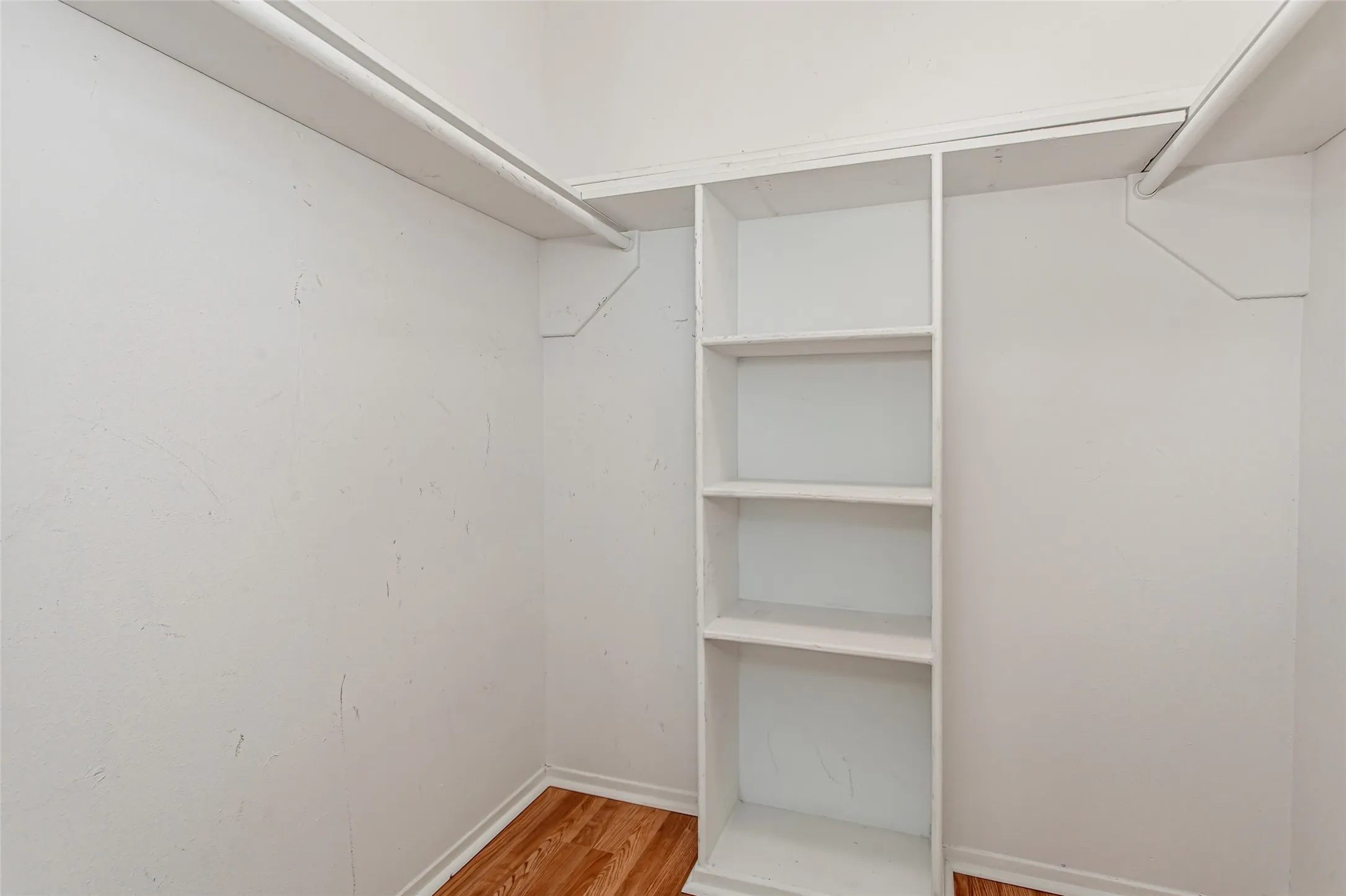 The secondary bedroom includes a walk-in closet complete with built-in shelving and double hanging rods, providing organization and storage rarely found in comparable townhomes.