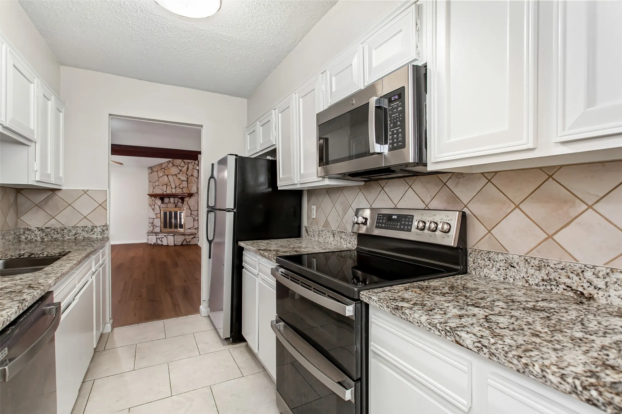 Well-appointed kitchen with stainless steel range, built-in microwave, granite countertops, and plentiful cabinet storage.  Kitchen opens to the living area, creating an ideal layout for everyday living and entertaining.