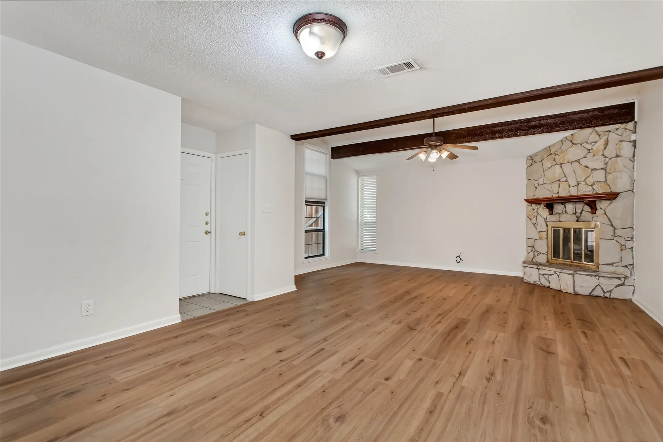 Dramatic floor-to-ceiling stone fireplace anchors the vaulted living room.