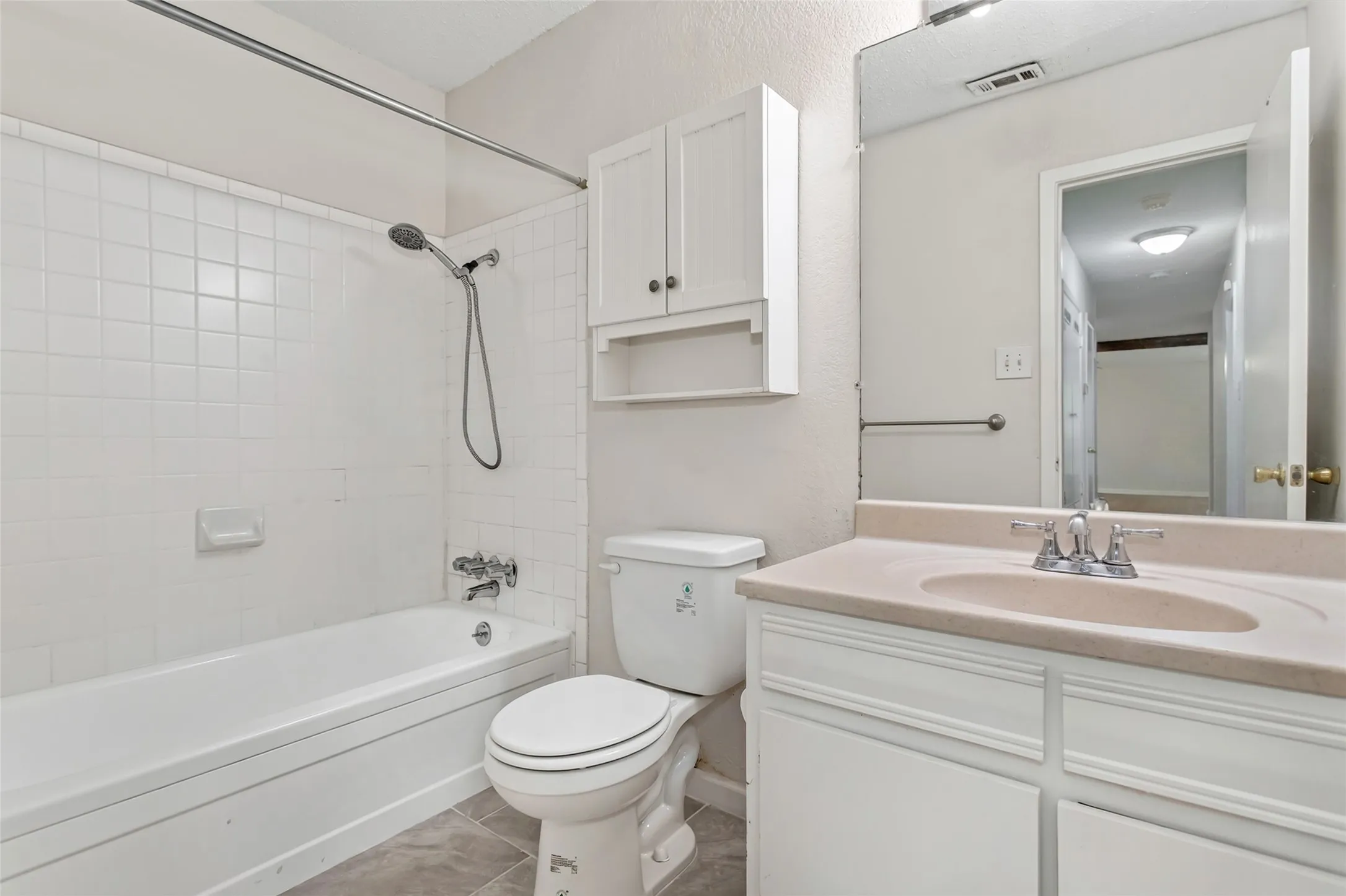 The secondary full bath features a tub/shower combination, vanity, and wall-mounted storage.