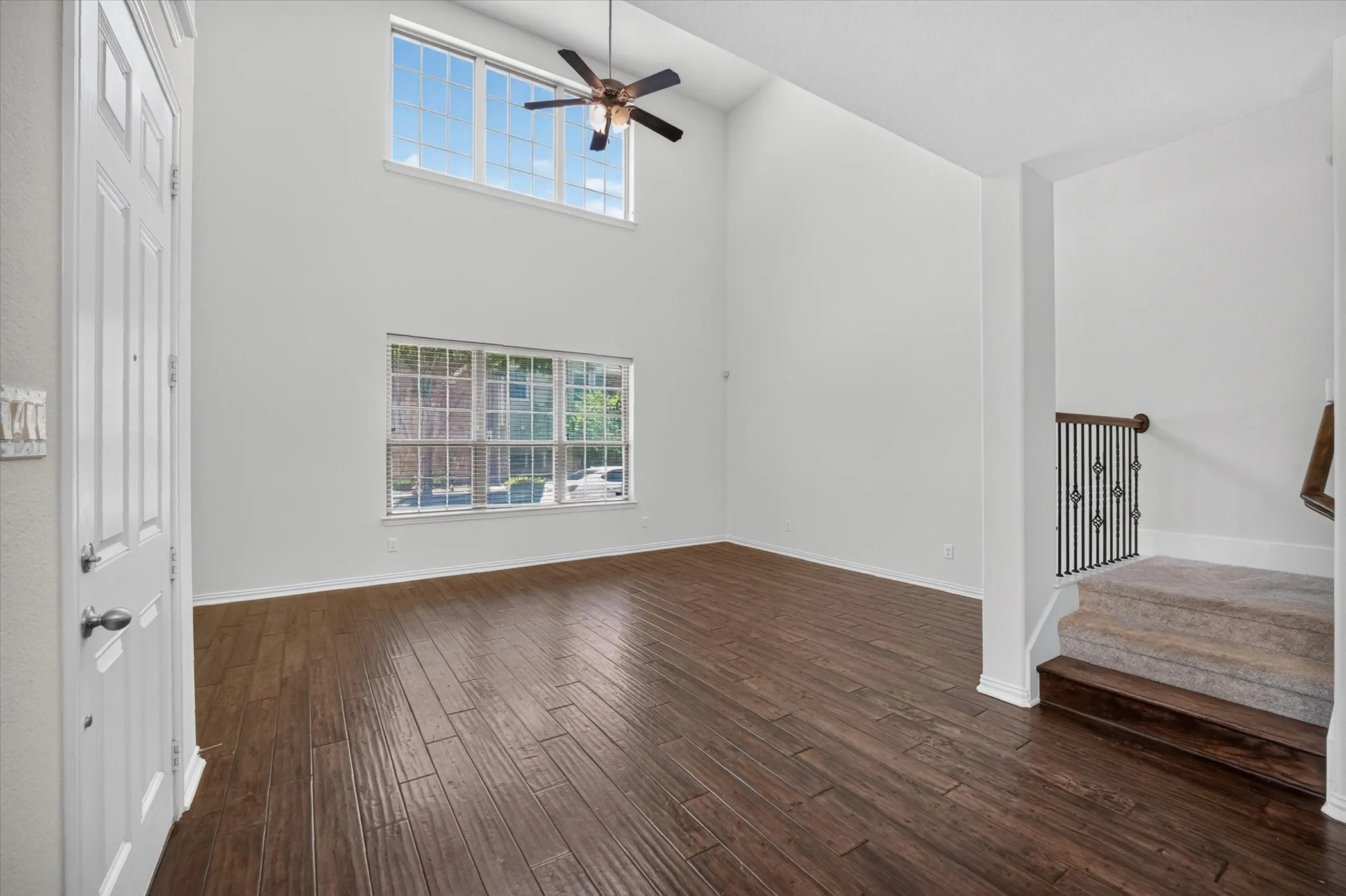 Two-story entryway featuring high ceilings, wood-finish flooring, and a multi-pane window array