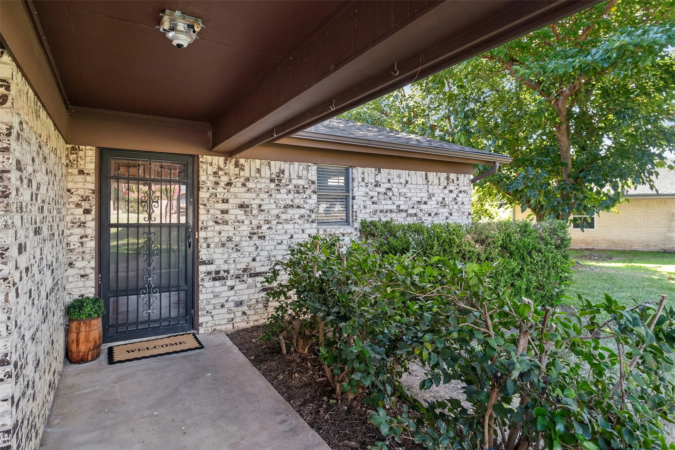 Covered front entry with mature landscaping