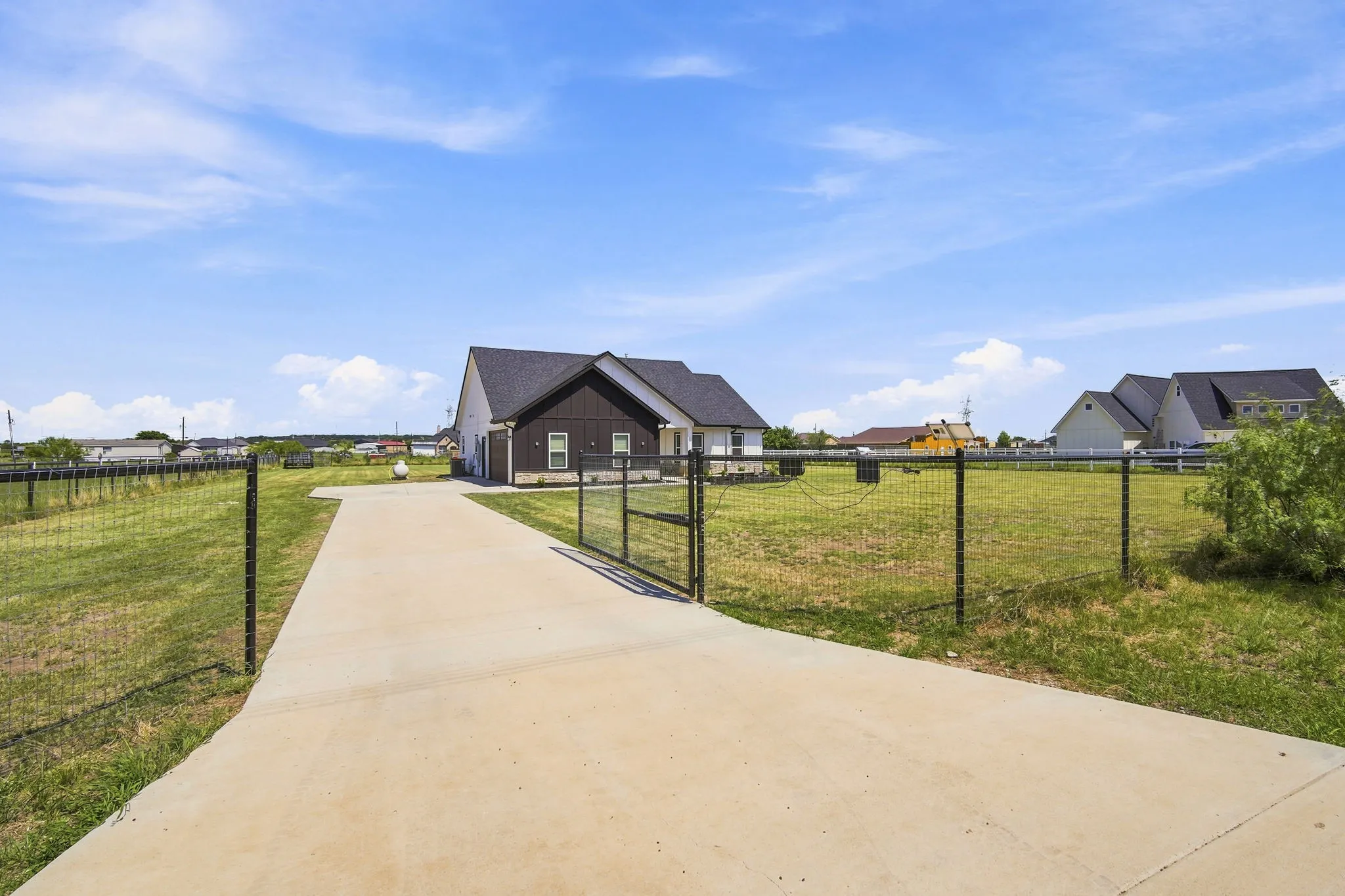 Inviting front view of the property from the driveway, complete with a gated entrance for added privacy.