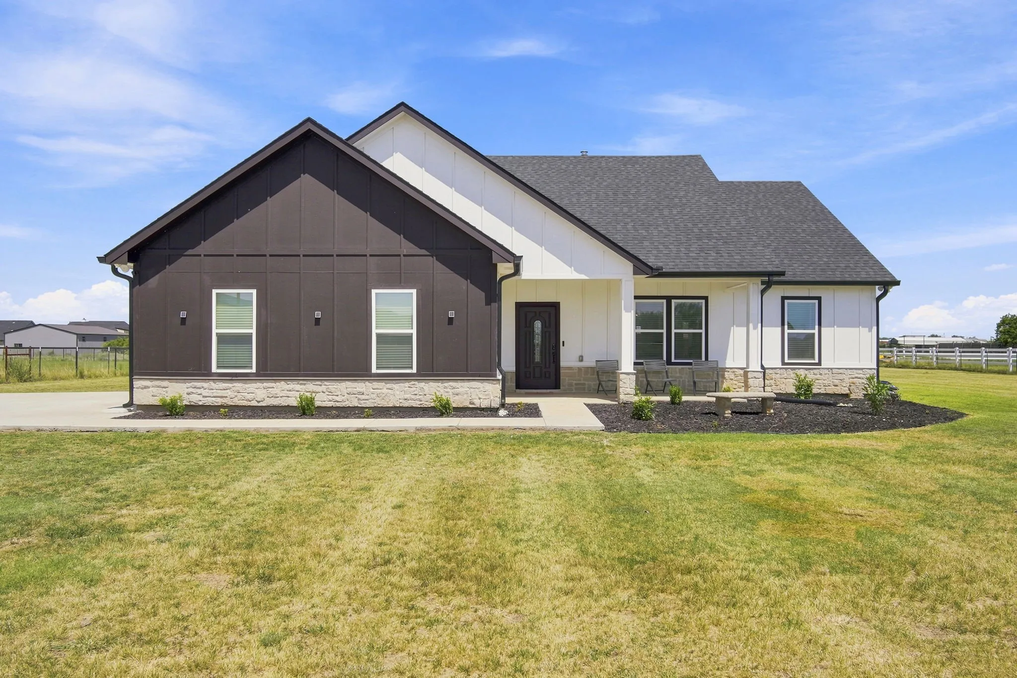 Charming front exterior featuring a brick and stone facade and a welcoming covered entry.