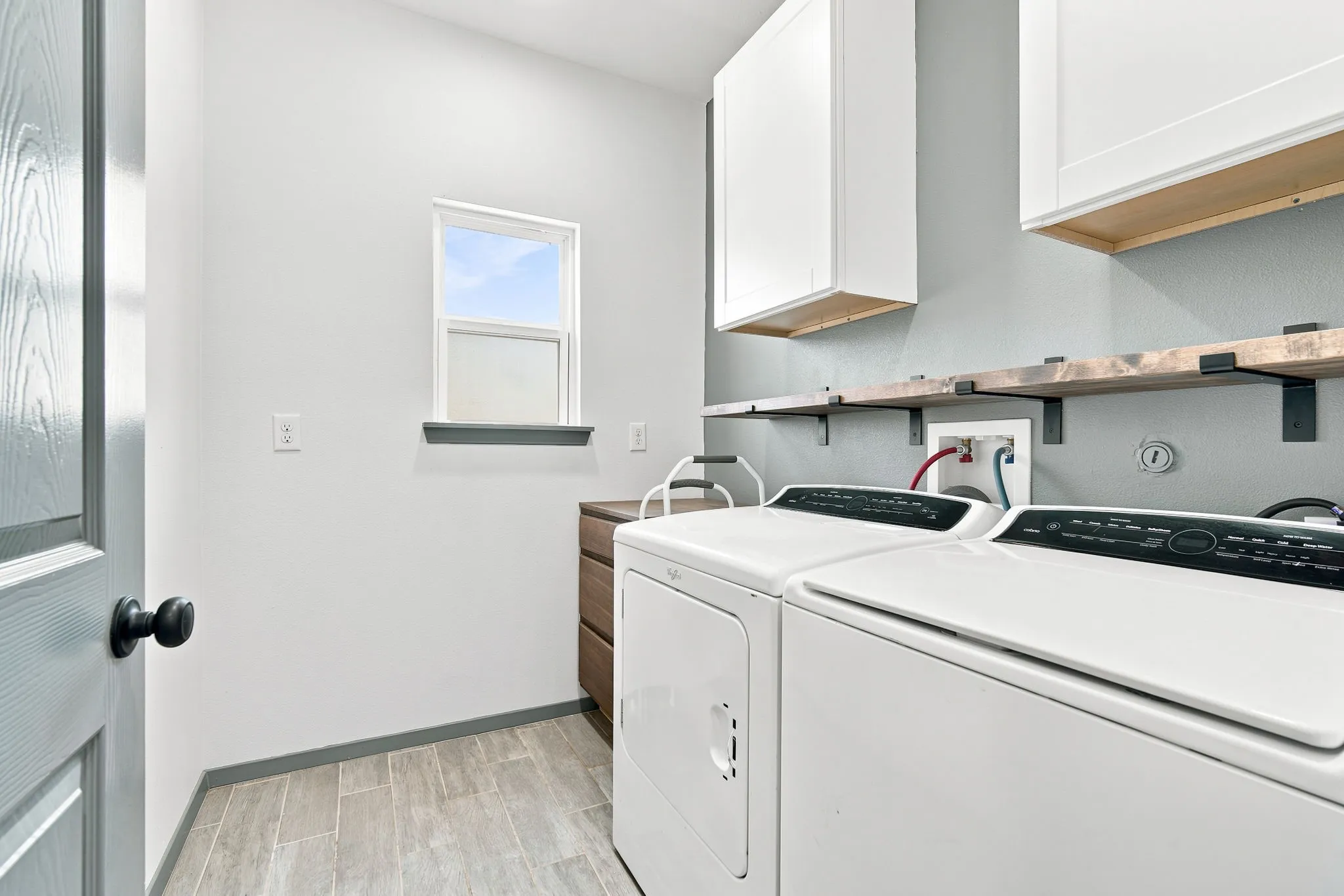 Practical utility room with counter space, cabinetry, ready for all your household needs.