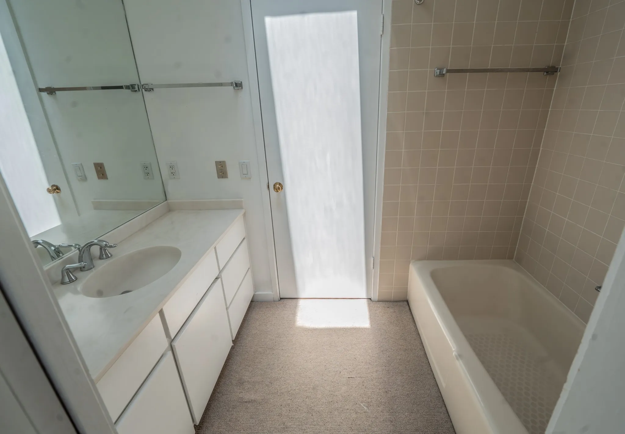 Bathroom featuring a single vanity with an integrated sink, polished chrome faucet, and a large mirror
