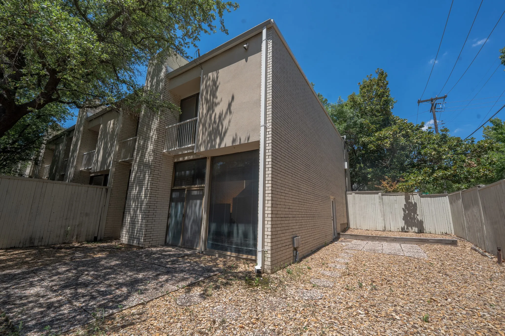 Multi-level building with a light brick facade and stucco accents