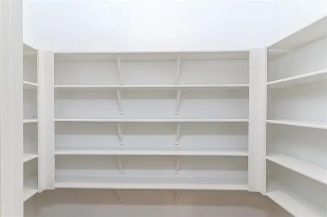Built-in shelving system featuring multiple white shelves and vertical supports