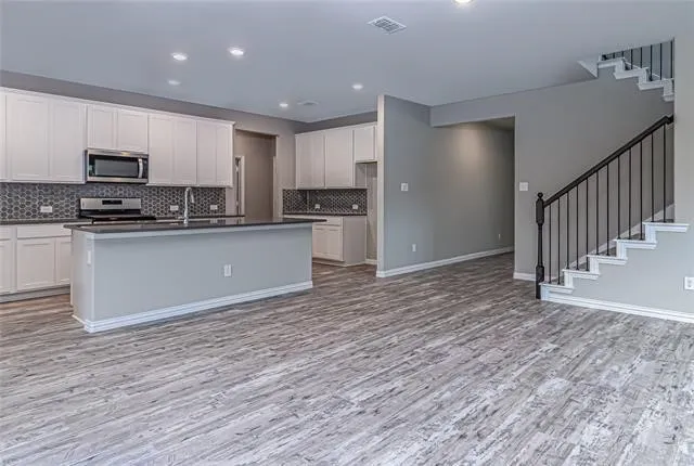Open-concept living space with wood-finish flooring extending into the kitchen