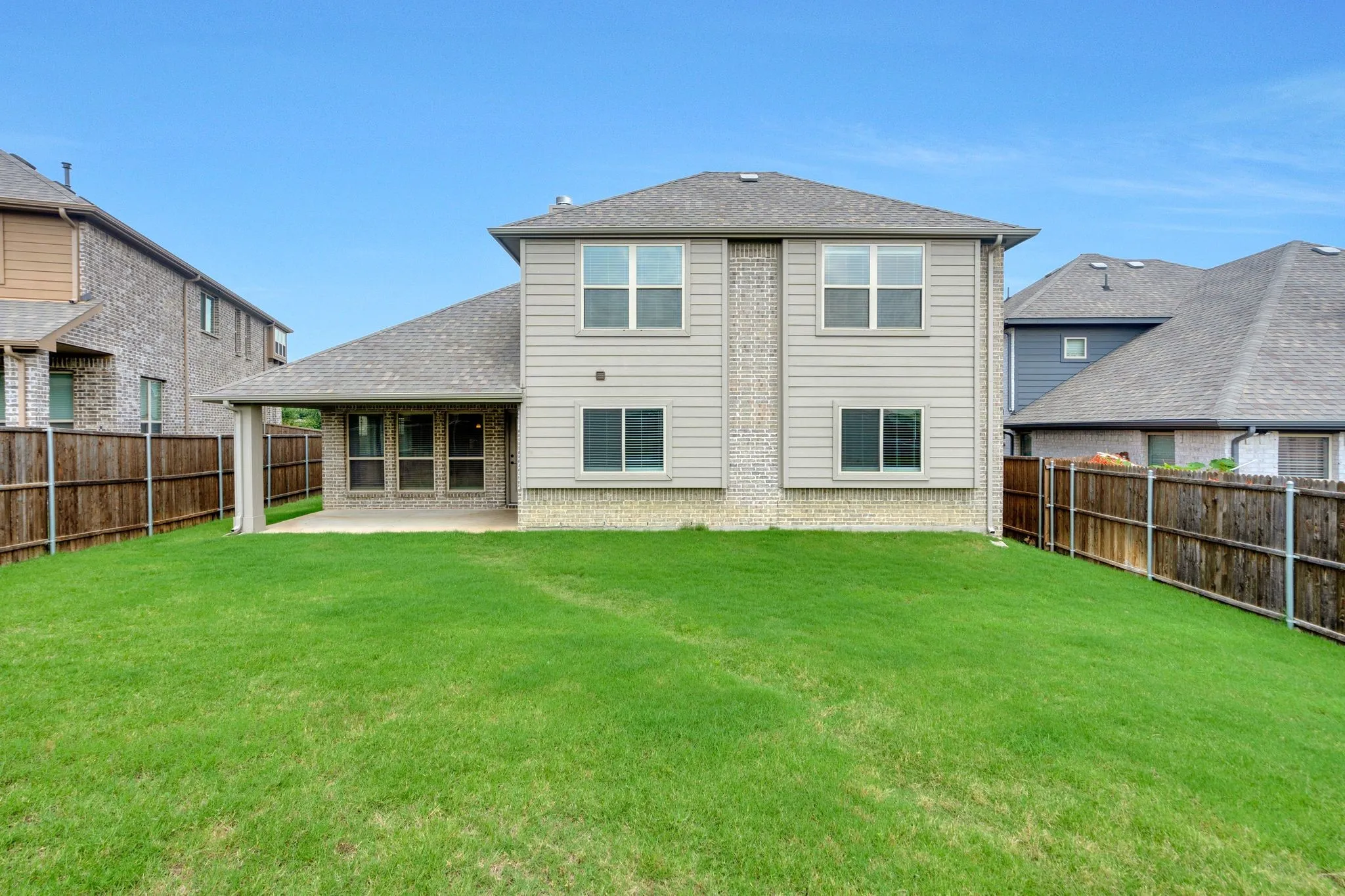 Outside, a covered patio overlooks a spacious yard.