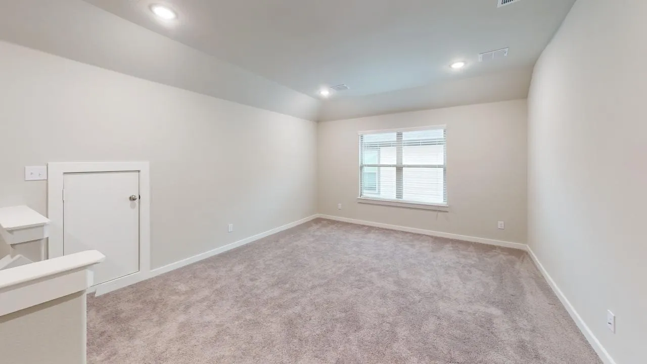 Carpeted room featuring a single window, white trim, recessed lighting, and a sloped ceiling