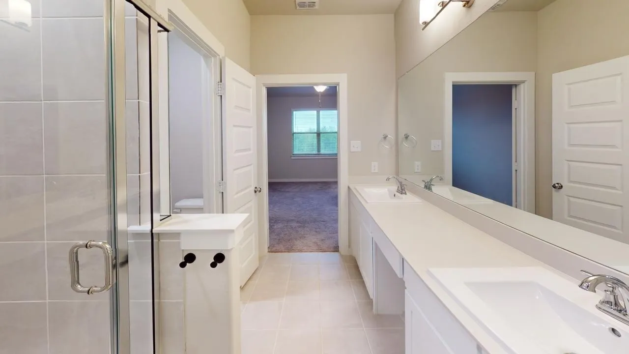 Modern bathroom featuring a double vanity with integrated sinks, a full-width mirror, and chrome fixtures