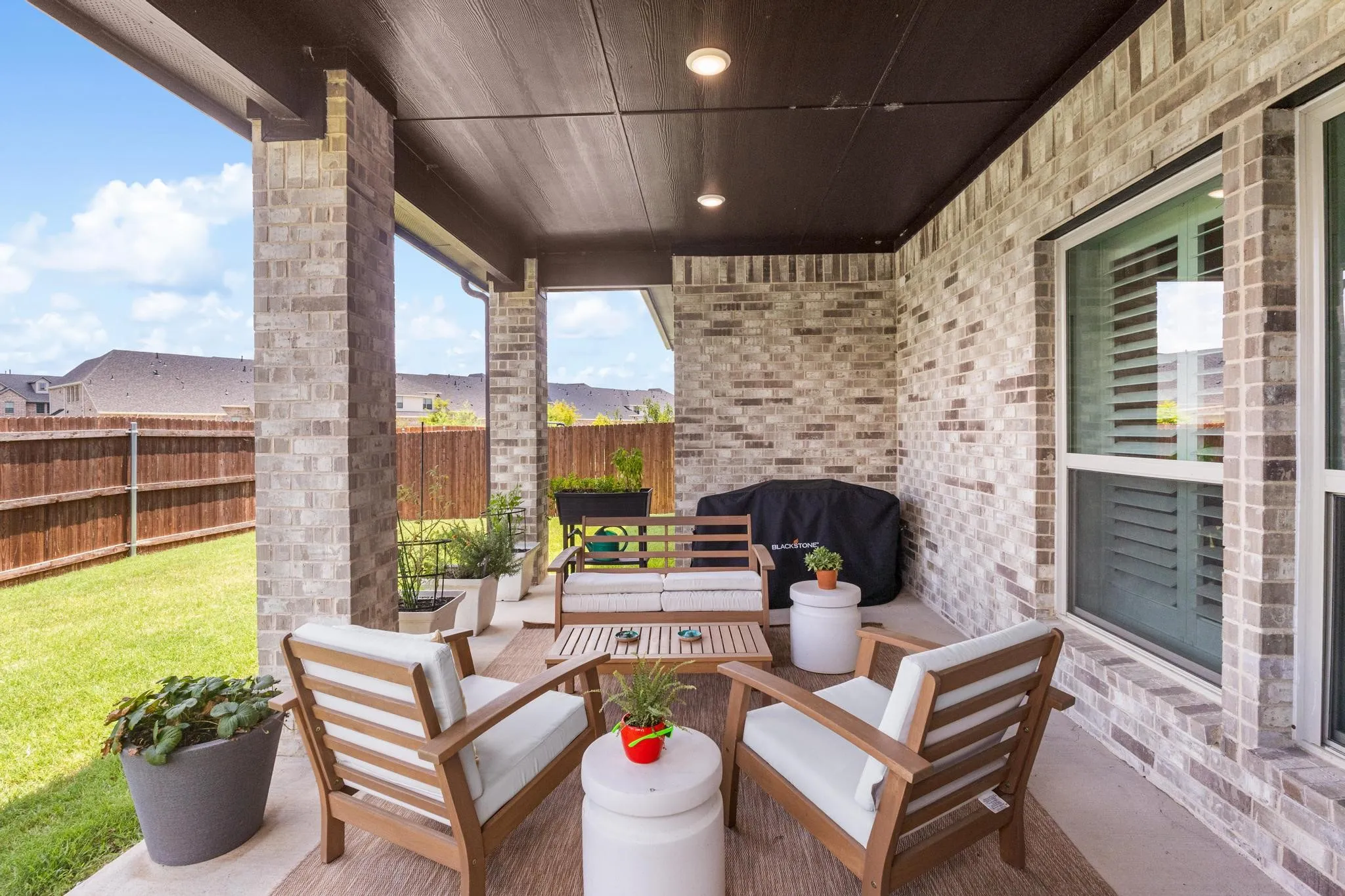 Covered patio with brick columns and recessed lighting