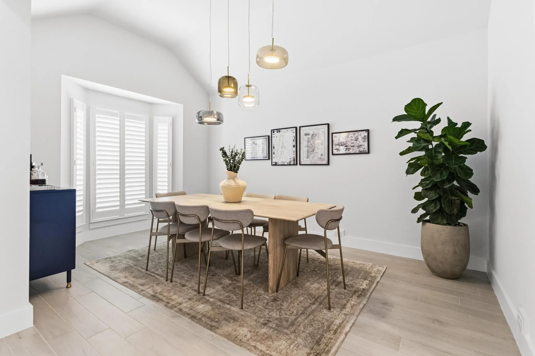 Dining area featuring a vaulted ceiling and light wood-finish flooring