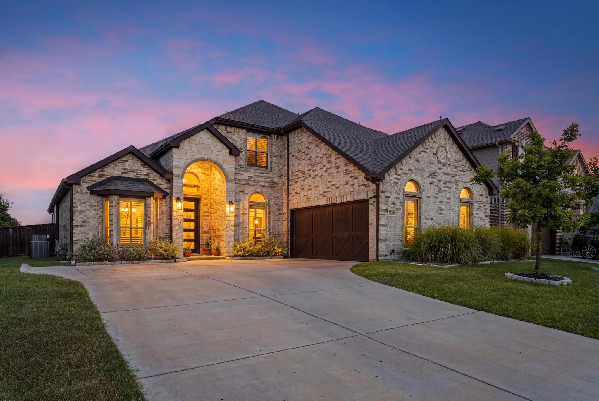 Two-story brick and stone exterior with dark trim