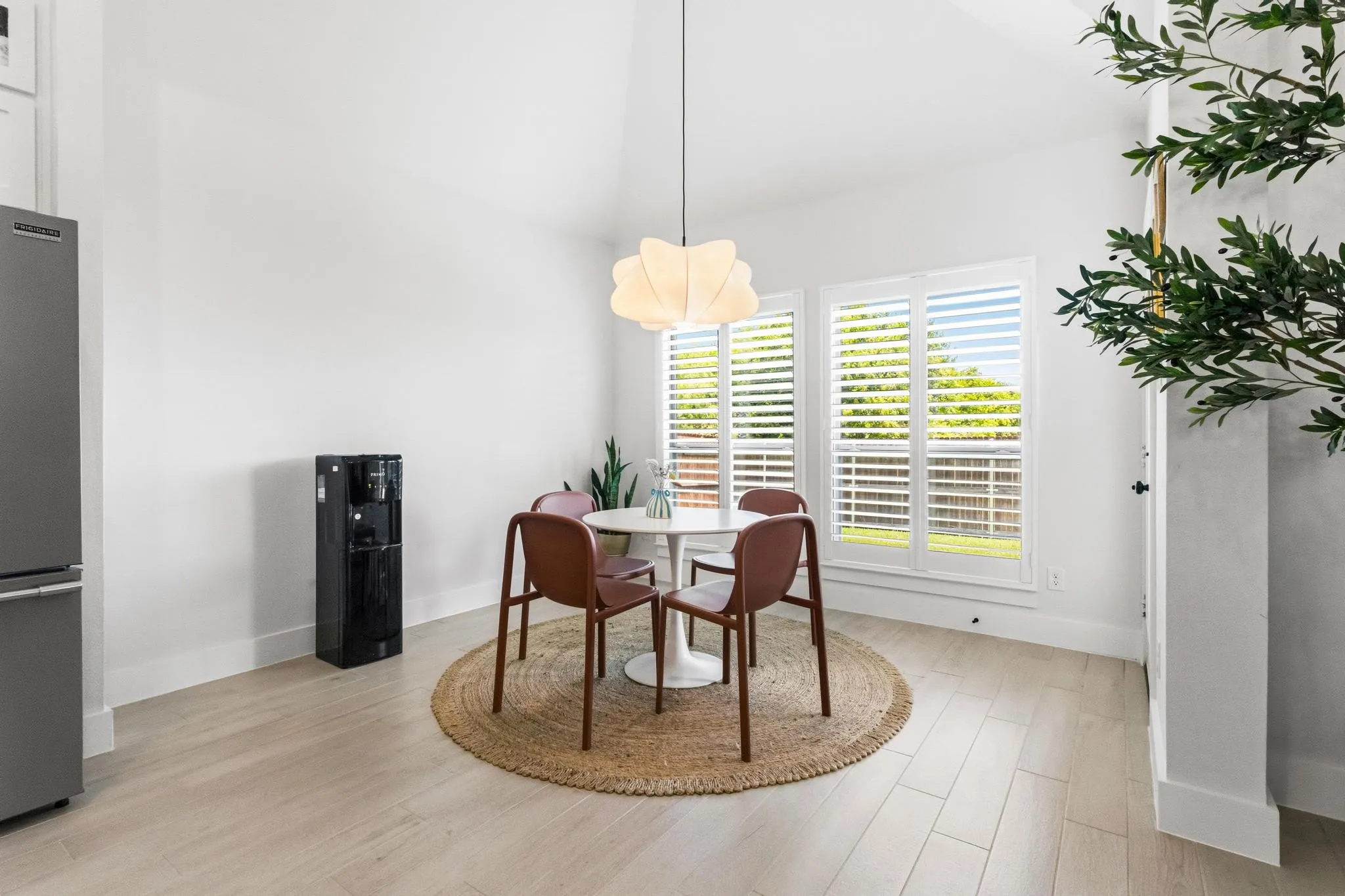Dining area featuring a vaulted ceiling and light wood-finish flooring