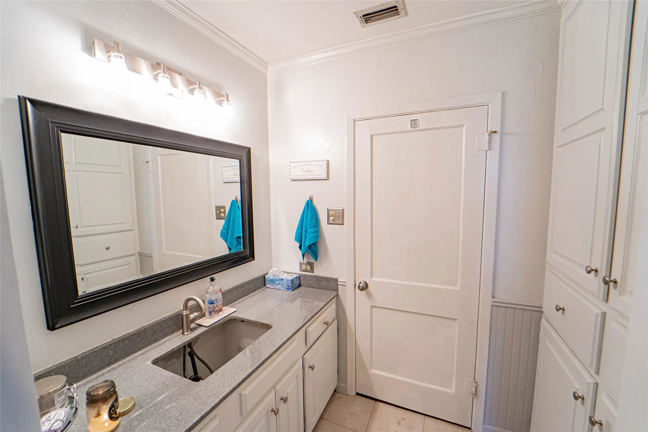 Bathroom vanity featuring a rectangular undermount sink, a gray countertop, and white cabinetry