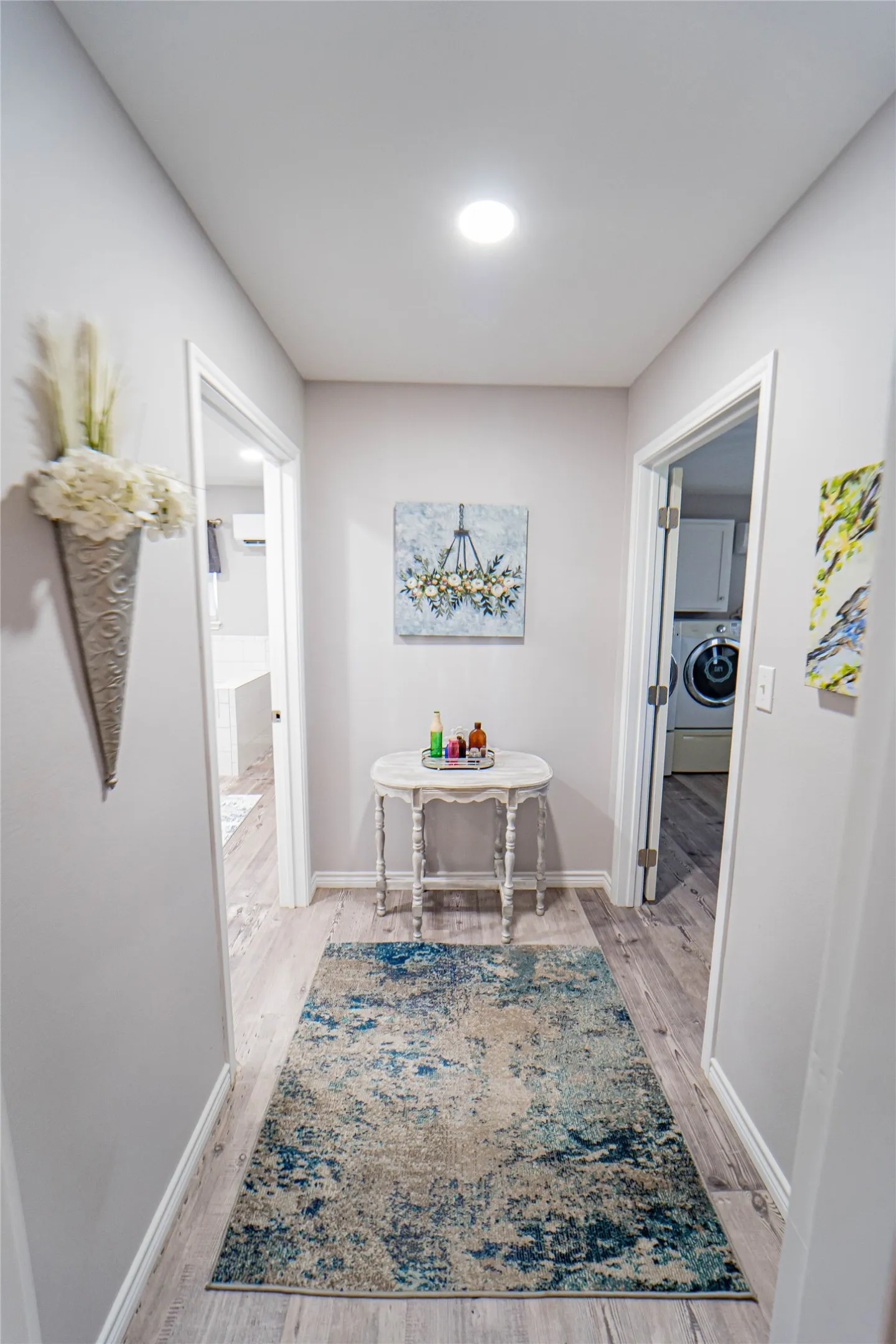 Hallway featuring recessed ceiling lighting, light gray wall paint, and wood-finish flooring-