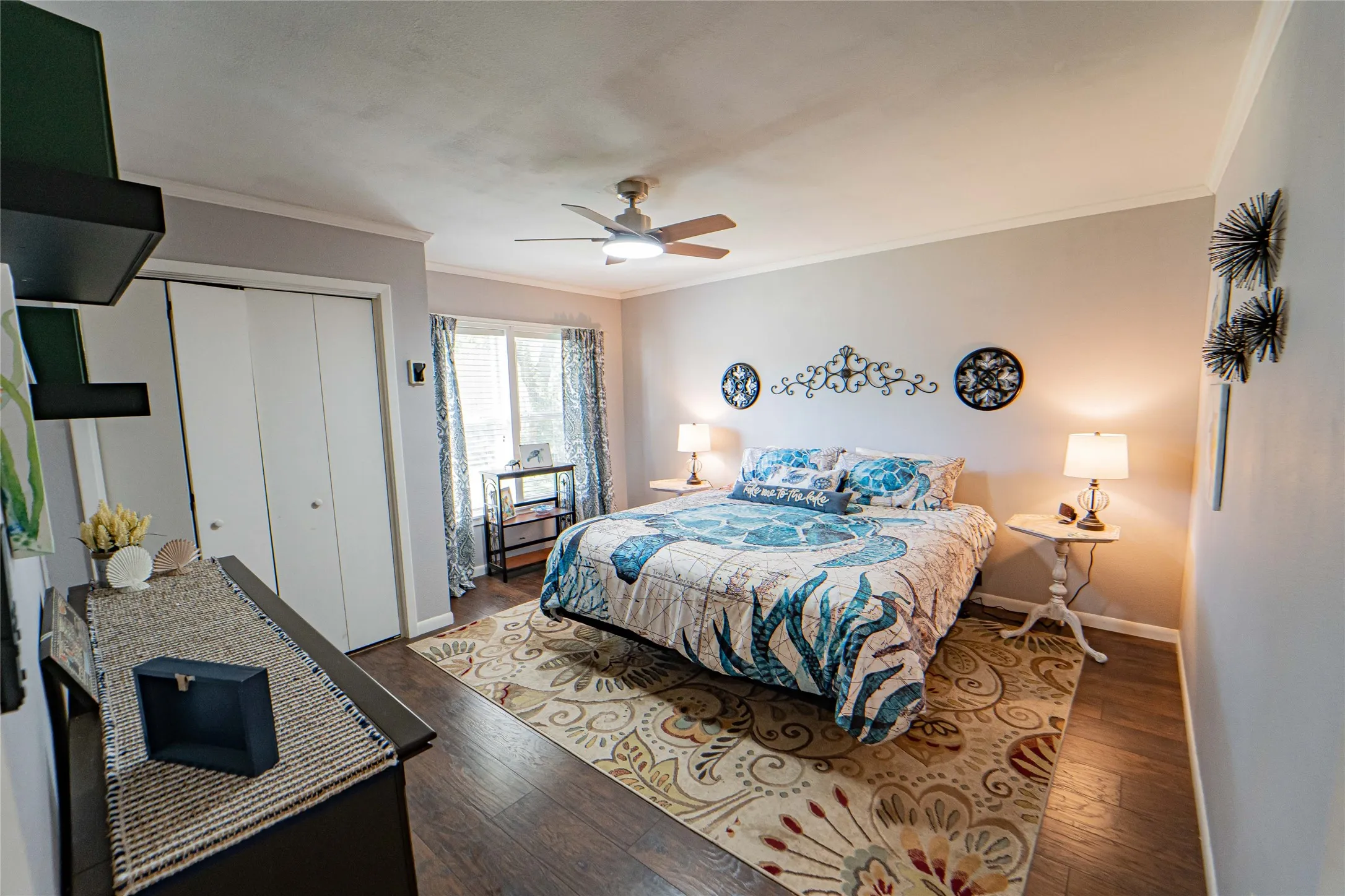 Large Guest Bedroom /Wood-finish flooring with a ceiling fan overhead