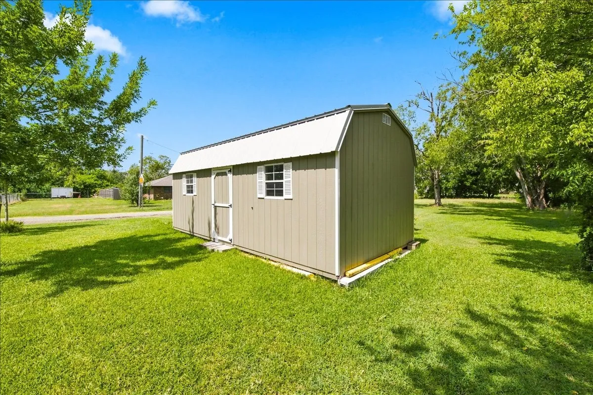 Exterior view of a large detached storage barn/outbuilding positioned on the property grounds.